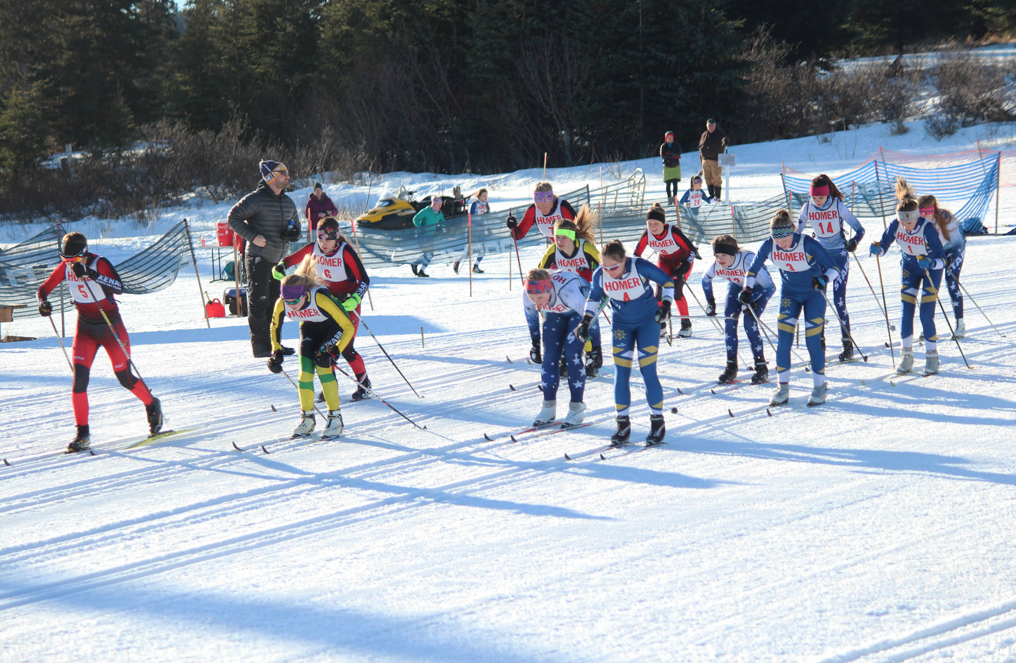 Skiers from Kenai Central High School, Soldotna High School, Homer High School and Seward High School take off from the starting line of the varsity girls’ 5 kilometer classic race Friday, Feb. 2, 2018 at an invitational at the Lookout Ski Trails near Homer, Alaska. (Photo by Megan Pacer/Homer News)