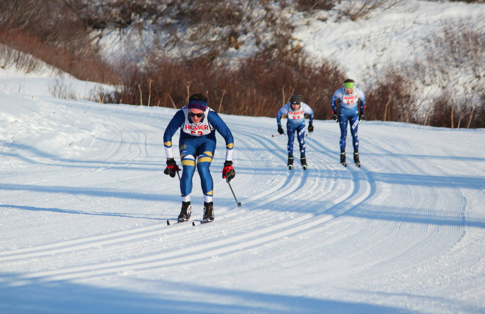 Homer’s Denver Waclawski leads two Soldotna High School skiers to the finish line of the varsity boys 5 kilometer classic race Friday, Feb. 2, 2018 at the Lookout Ski Trails near Homer, Alaska. Waclawski took third in the race. (Photo by Megan Pacer/Homer News)