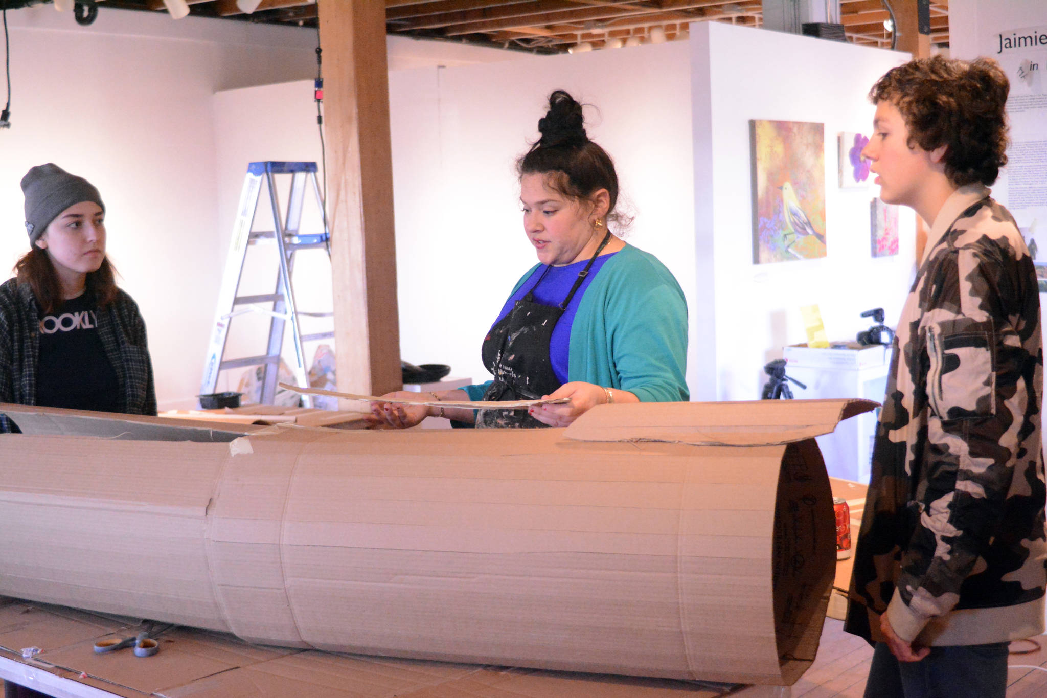 TOP: Artist in Residence Jaimie Warren, center, discusses how to make a log costume with Mila Stickrod, left, and Alex Franklin, right, at her temporary studio at Bunnell Street Arts Center. The Brooklyn, New York, artist visits Homer this month. (Photo by Michael Armstrong, Homer News)