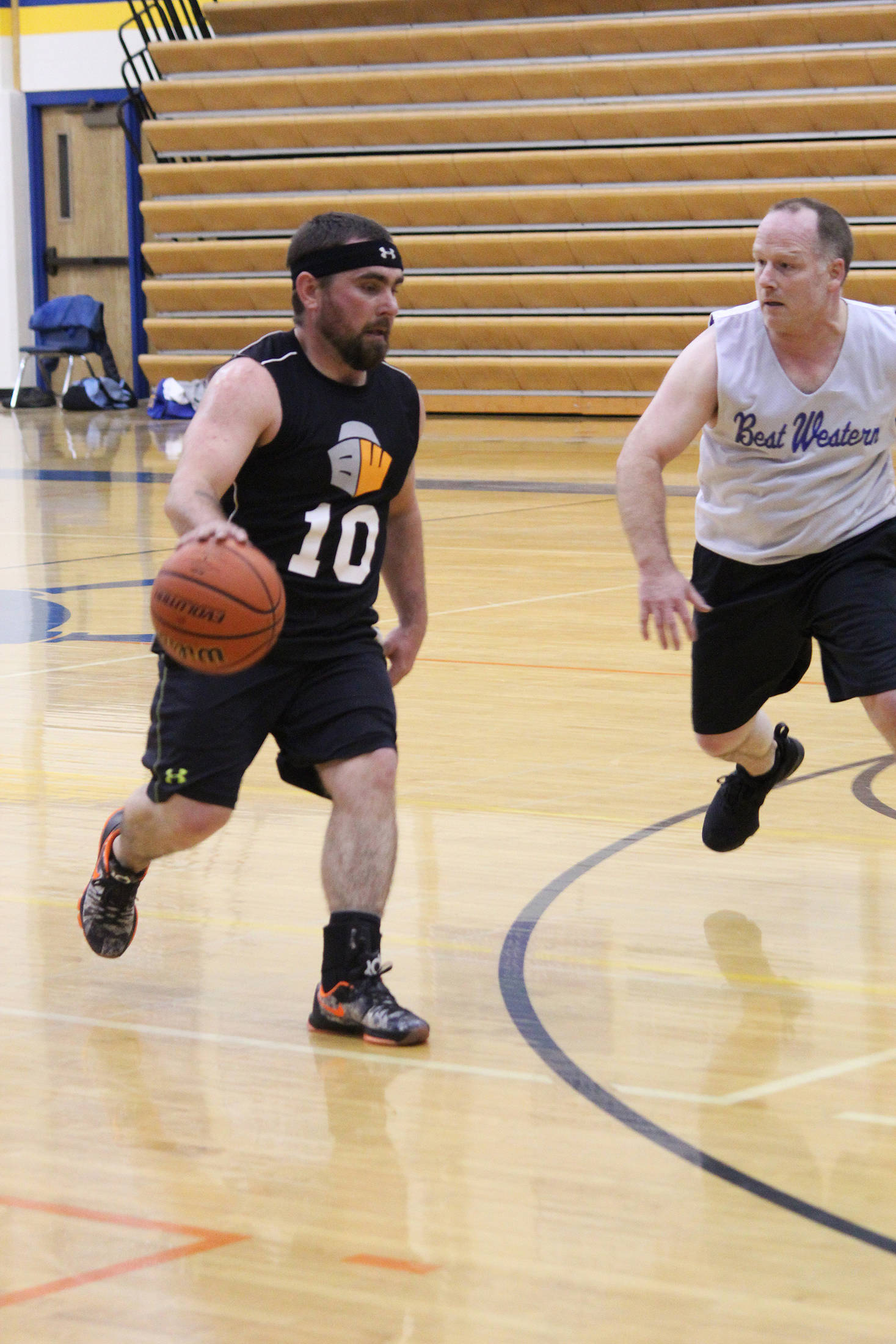David Drake (left) dribbles past Heath Smith during the Homer city basketball league’s championship game Monday, March 5, 2018 at Homer High School. (Photo by Megan Pacer/Homer News)