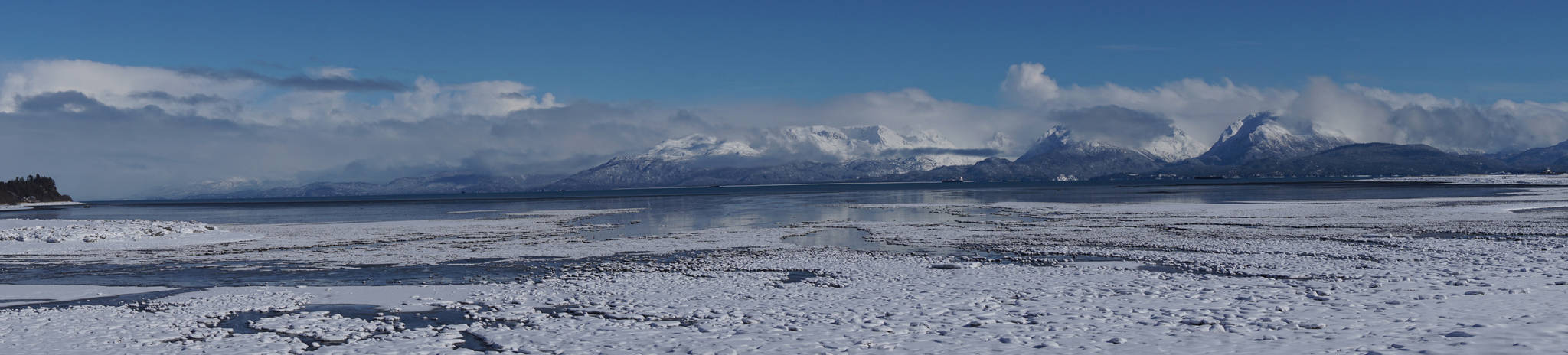 Snowfall over the weekend covered ice floes on Mud Bay in this panoramic view of the Kenai Mountains and the Spit on Saturday, March 10, 2018 in Homer, Alaska. (Photo by Michael Armstrong, Homer News)