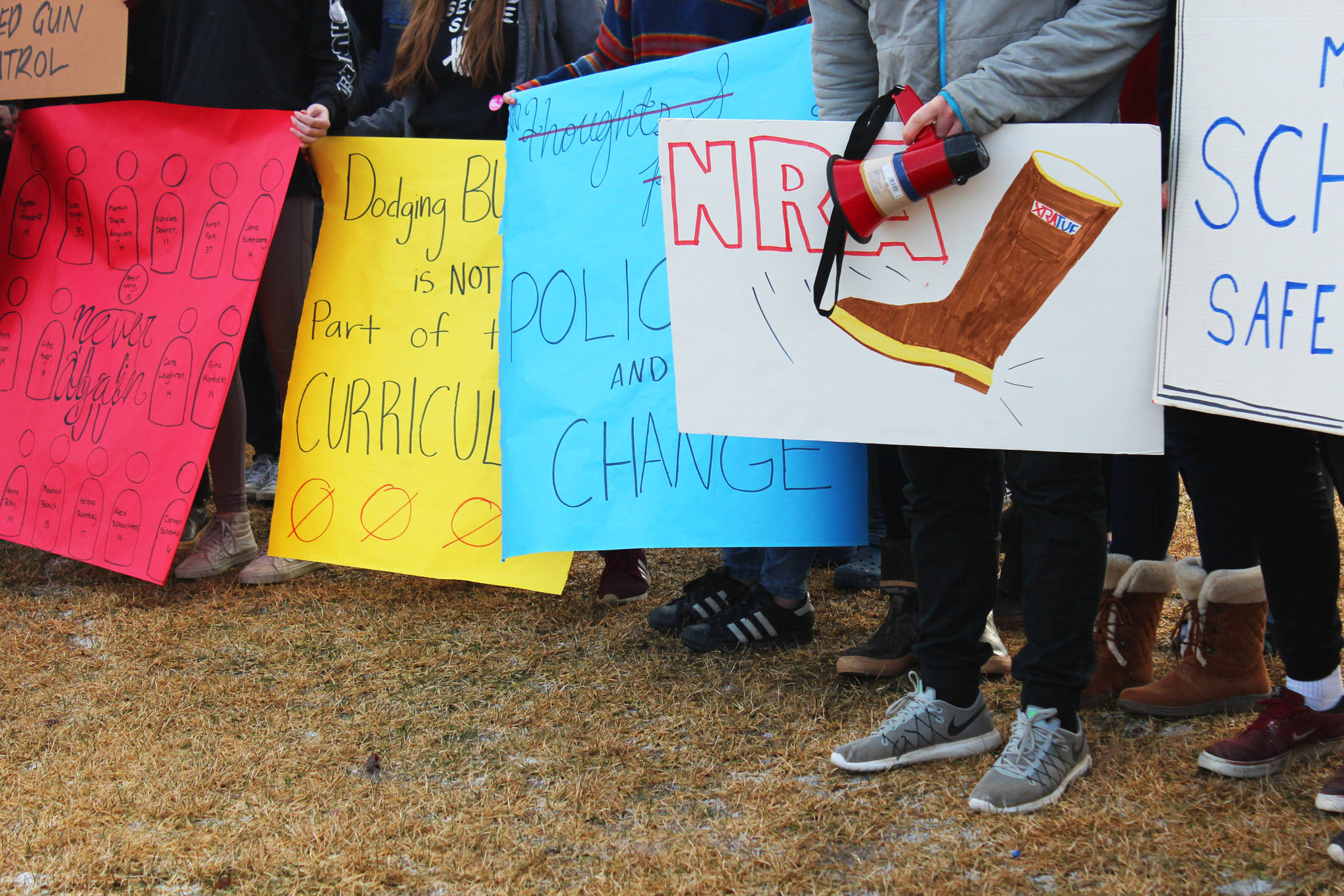 Homer High School students stand in a group with signs advocating for safer schools and stricter gun laws during a walkout staged at noon Wednesday, Feb. 21, 2018 at the school in Homer, Alaska. (Photo by Megan Pacer/Homer News)