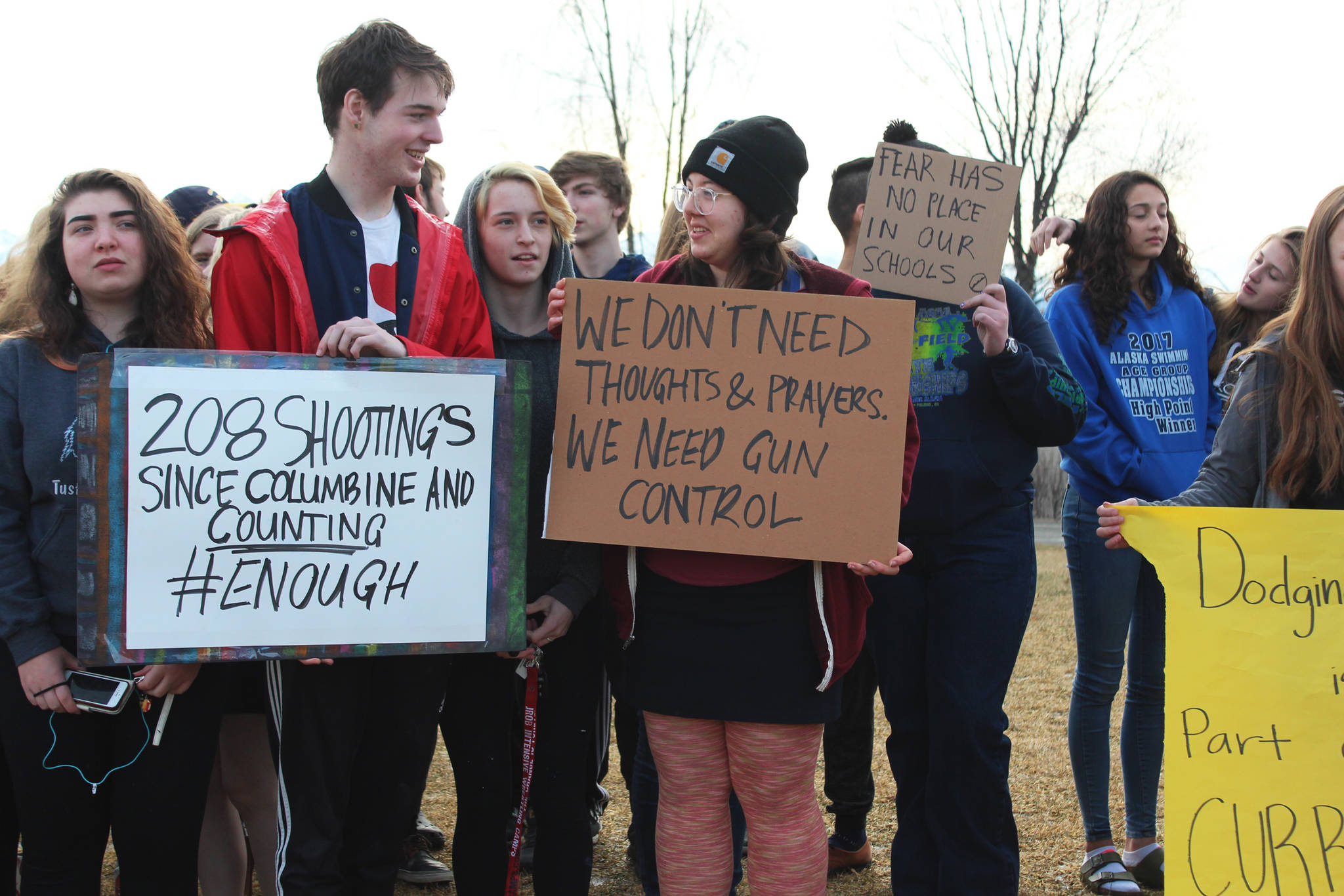 Senior Elan Carroll and senior Drew Wimmerstedt stand with about 100 of their classmates, and some staff, during a walkout Wednesday, Feb. 21, 2018 at Homer High School in Homer, Alaska. The signs, made by Wimmerstedt, read “208 shootings since Columbine and counting. #Enough,” and “We don’t need thoughts and prayers, we need gun control.” (Photo by Megan Pacer/Homer News)
