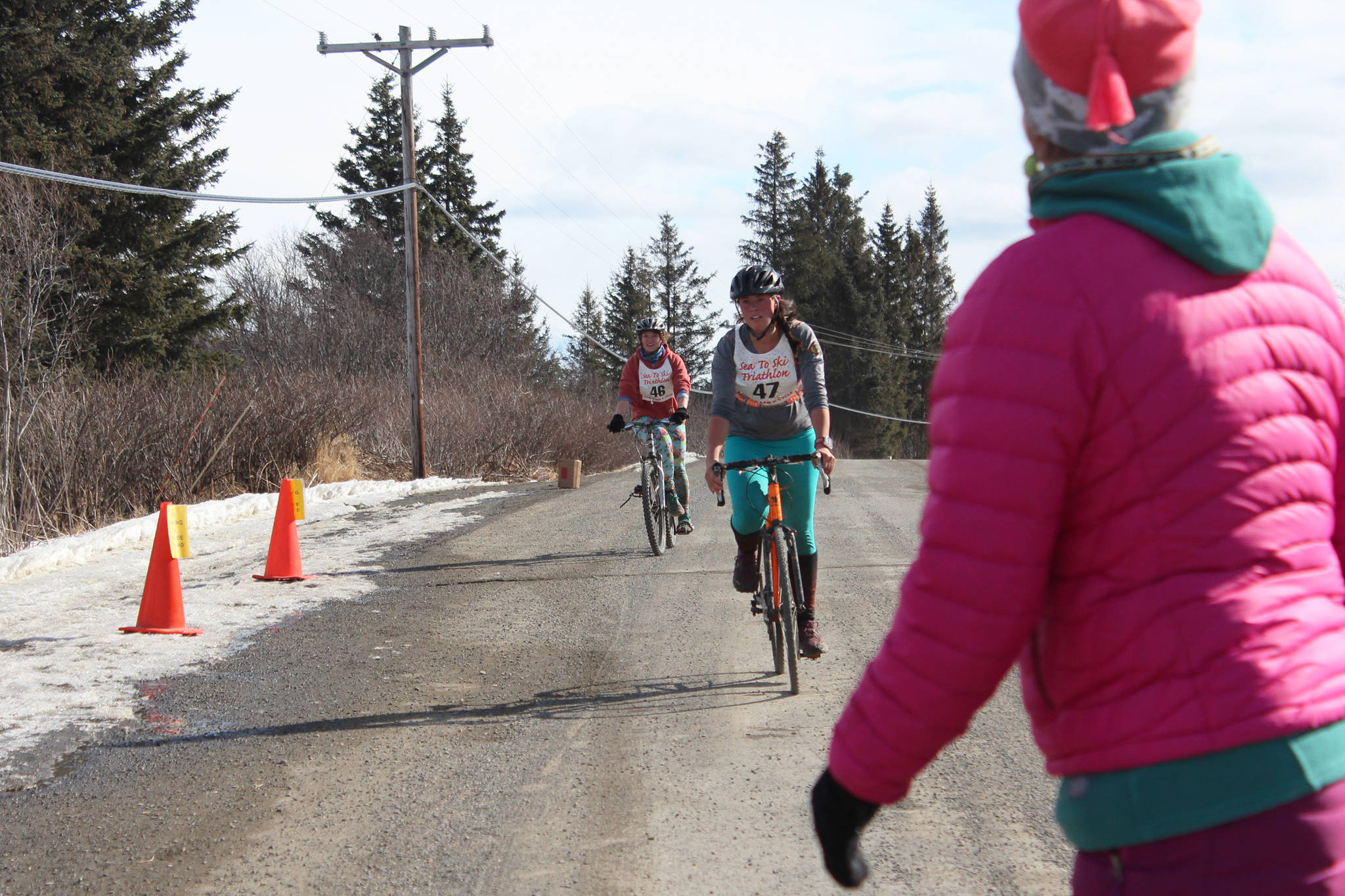 Two cyclists approach the transition area of this year’s Sea to Ski Triathlon on Highland Avenue on Sunday, March 25, 2018 in Homer, Alaska. The bike portion of the race takes participants on a brutal climb up West Hill Road. (Photo by Megan Pacer/Homer News)