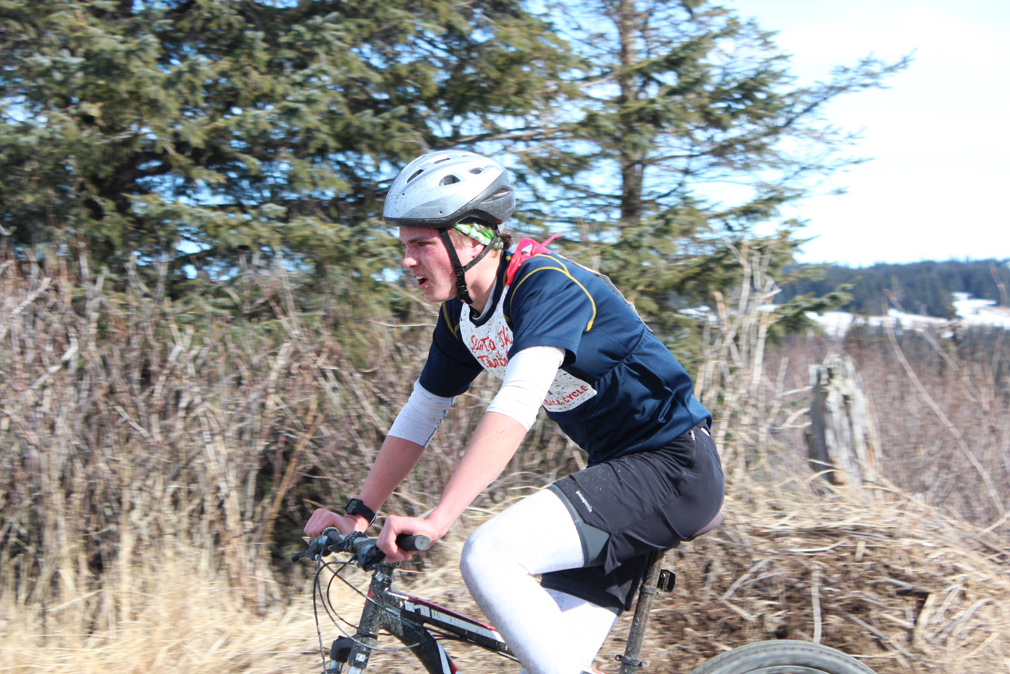 Homer High School senior Denver Waclawski bikes into the second transition station of this year’s Sea to Ski Triathlon. He finished first in all three legs of the race and took first place overall Sunday, March 25, 2018 in Homer, Alaska. (Photo by Megan Pacer/Homer News)