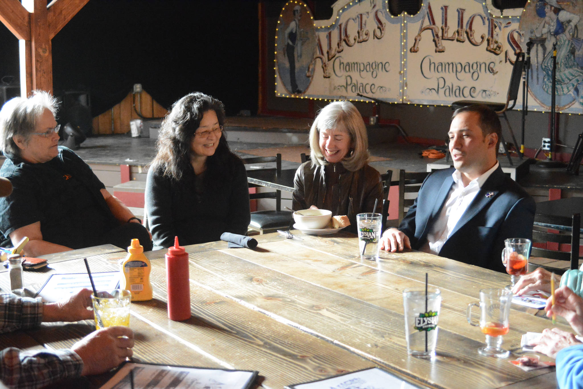 Dimitri Shein, far right, speaks to about 15 people at Alice’s Champagne Palace on Monday, March 26, in Homer, Alaska. (Photo by Michael Armstrong, Homer News)