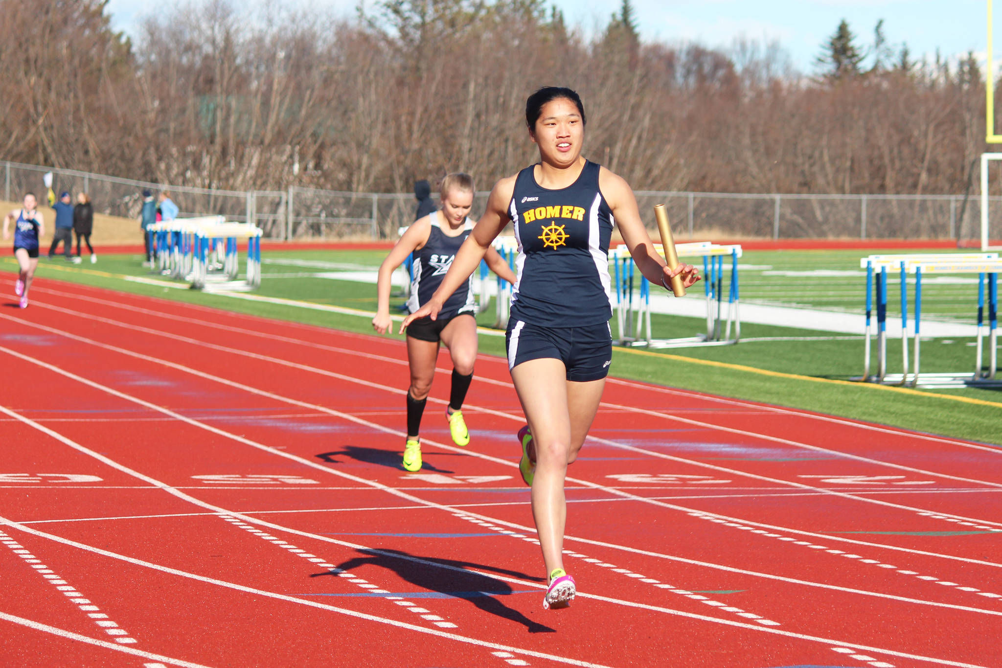 Photo by Megan Pacer/Homer News Homer’s Kailee Veldstra crosses the finish line of the girls’ 400-meter relay to claim first place for her team Friday, April 13 at Homer High School.