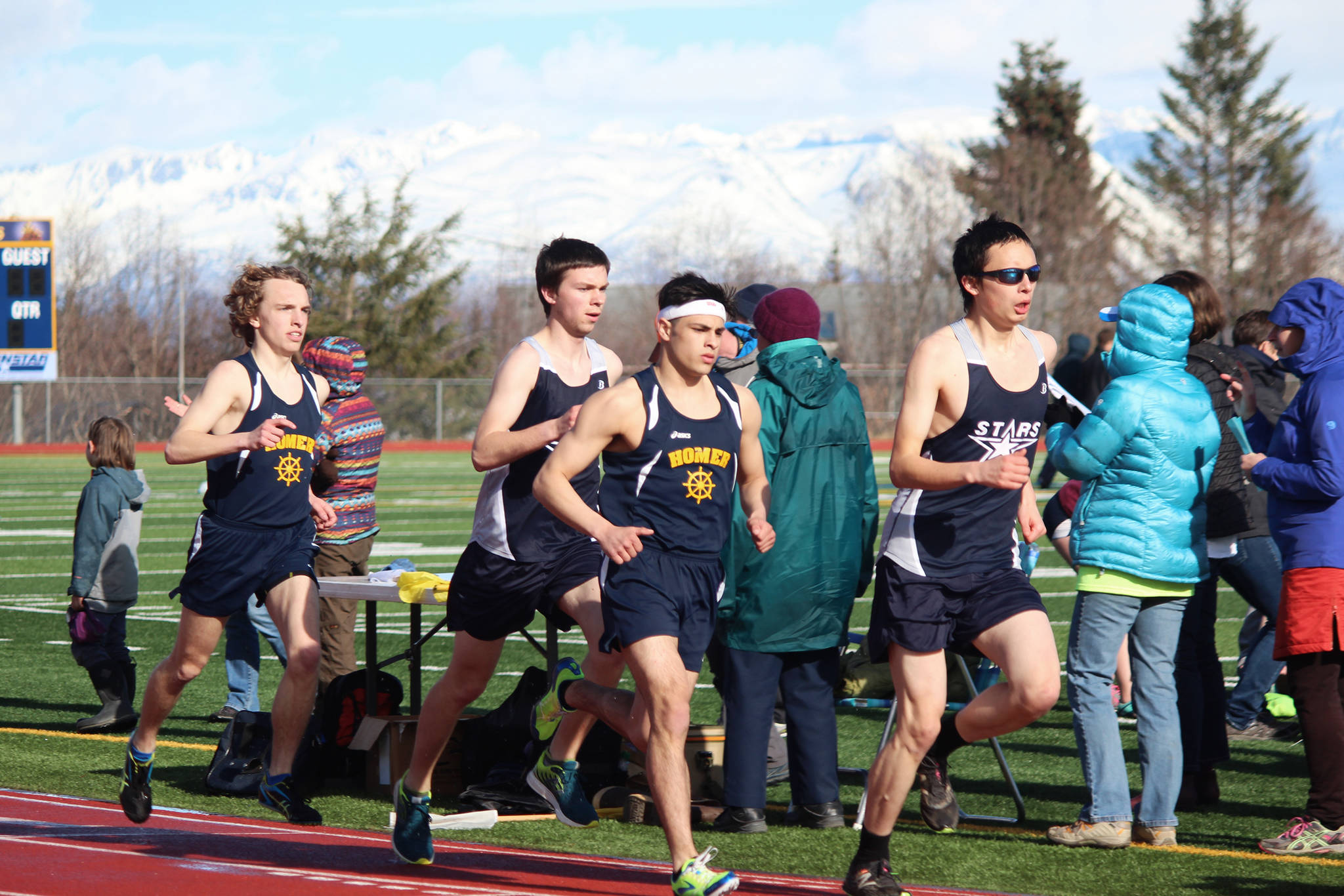 Homer’s Jacob Davis, Soldotna’s Josh Shuler, Homer’s Luciano Fasulo and Soldotna’s Sean Vergin lead the boys’ 1,600-meter run Friday, April 13, 2018, at Homer High School in Homer, Alaska. Fasulo took first in the event at the dual meet between the two schools. (Photo by Megan Pacer/Homer News)