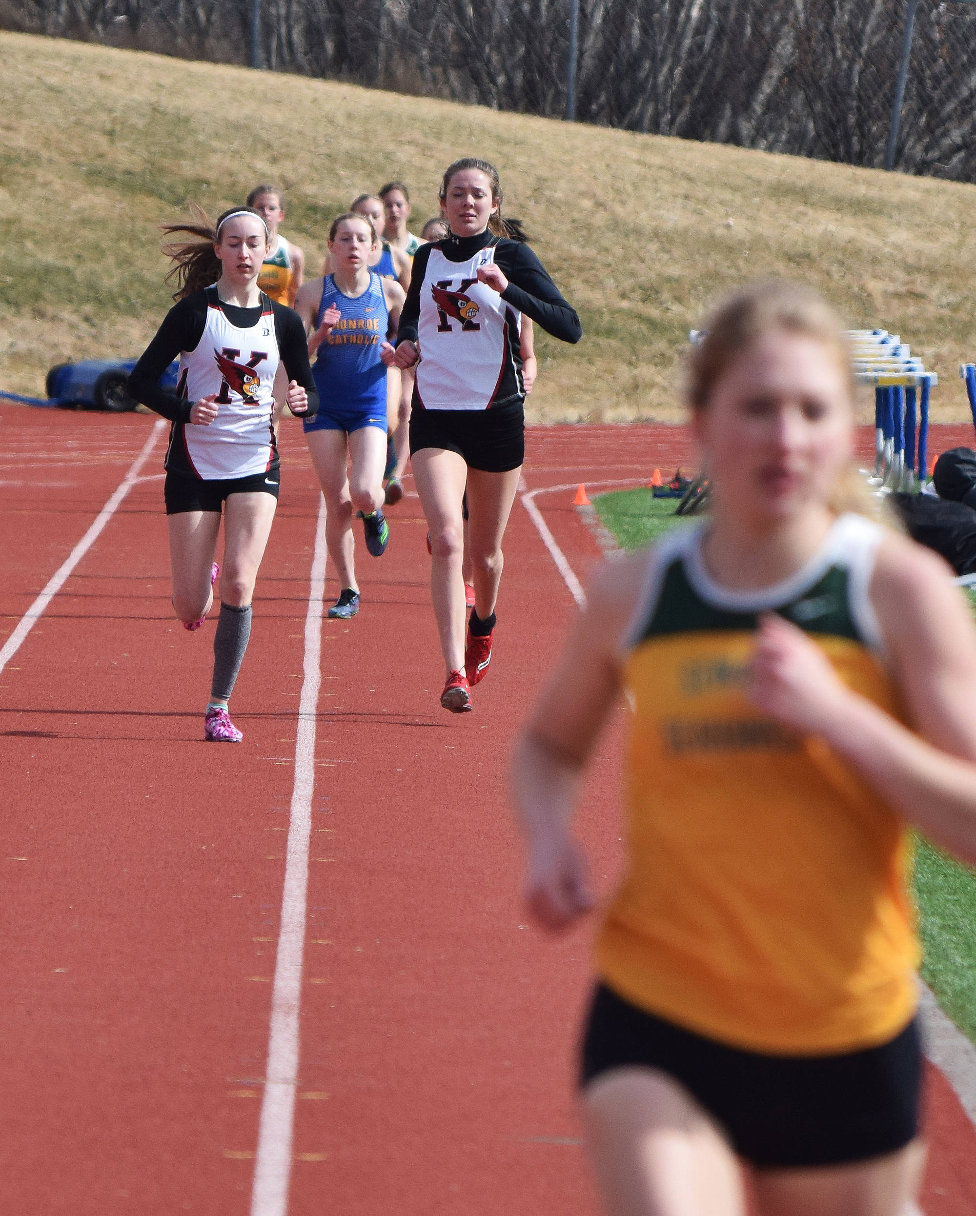 Kenai Central teammates Jaycie Calvert (left) and Brooke Satathite trail race leader Ruby Lindquist of Seward in the girls 1,600 meters Saturday afternoon at Homer High School. (Photo by Joey Klecka/Peninsula Clarion)