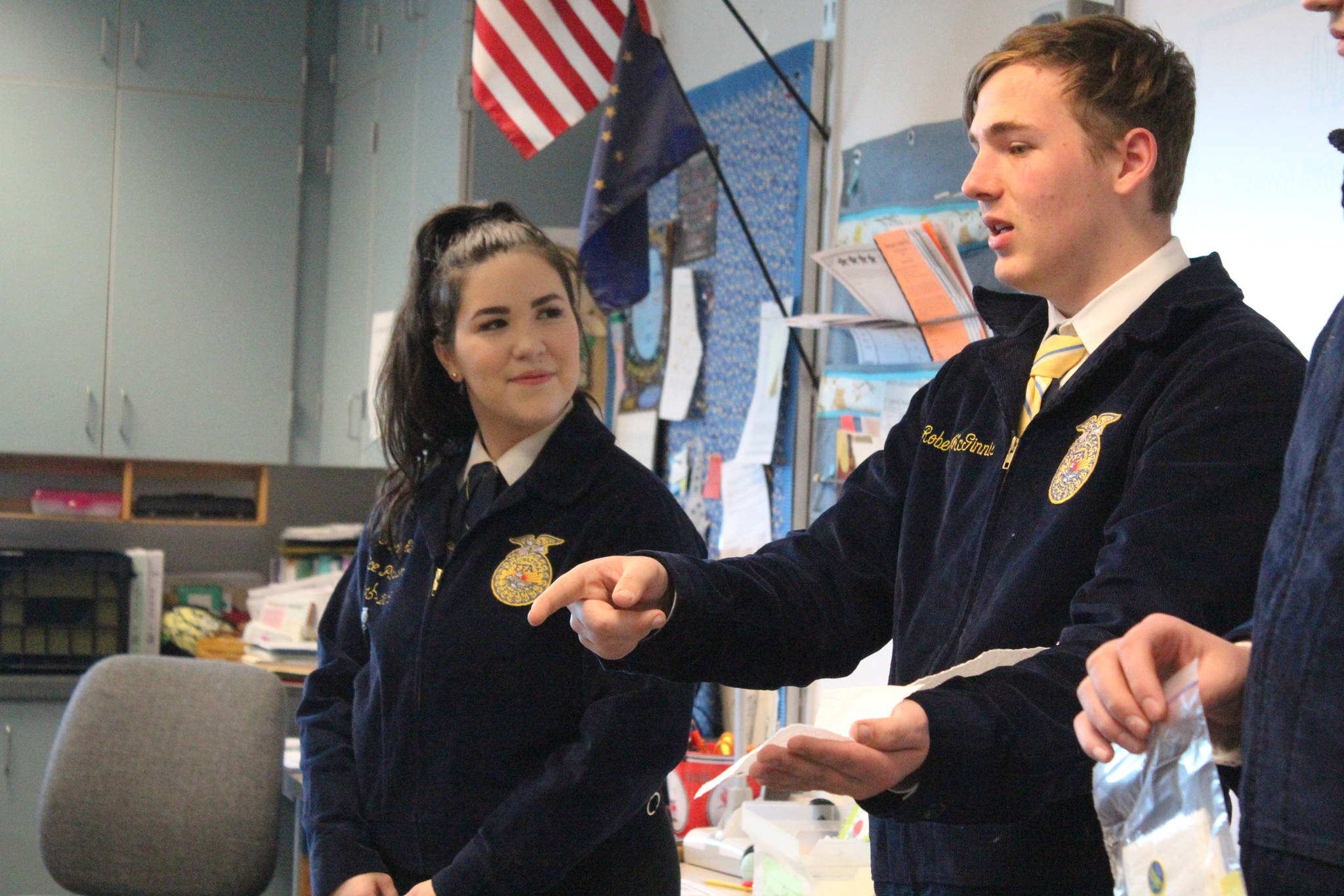 Ninilchik School junior Jodie Kain, senior Robert McGinnis, center, and sophomore Jacob Clark, far right, explain a seed tape project to a group of fourth, fifth and sixth graders Tuesday, May 1, 2018 at the school in Ninilchik, Alaska. The Ninilchik chapter of the National FFA Organization brought a program to the younger students for the first time, teaching them about planting carrot seeds, in honor of Alaska Agriculture Day. (Photo by Megan Pacer/Homer News)