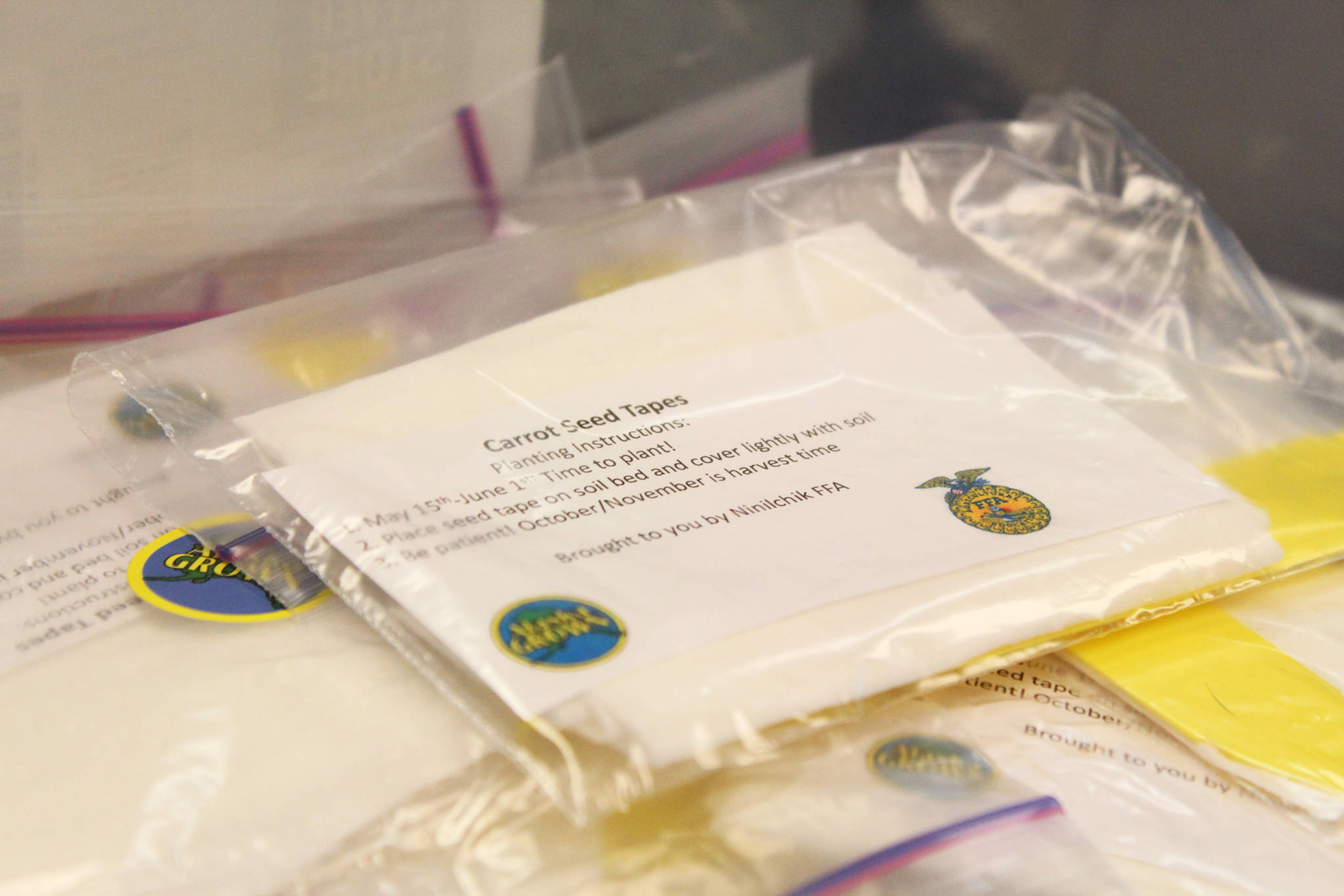 Packets with planting instructions lie in a box waiting to be opened by eager students Tuesday, May 1, 2018 at Ninilchik School in Ninilchik, Alaska. Members of the Ninilchik chapter of the National FFA Organization visited the school to teach them how to made seed tapes, or a way or readying and storing seeds for later planting. (Photo by Megan Pacer/Homer News)