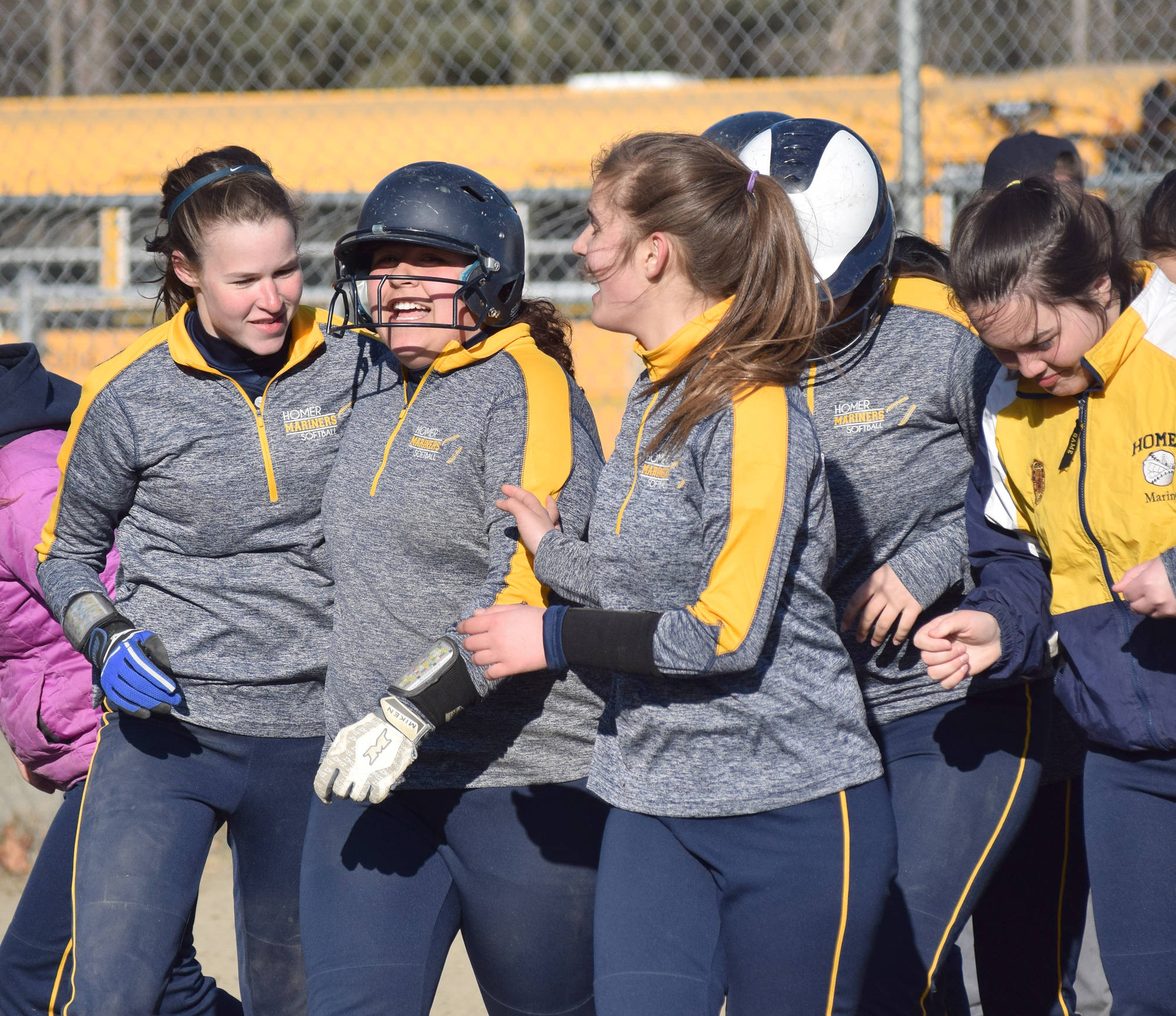Photo by Joey Klecka/Peninsula Clarion Homer junior Brianna Hetrick (second from left) celebrates with her teammates after touching home plate following a home run Tuesday evening at the Soldotna Little League fields.