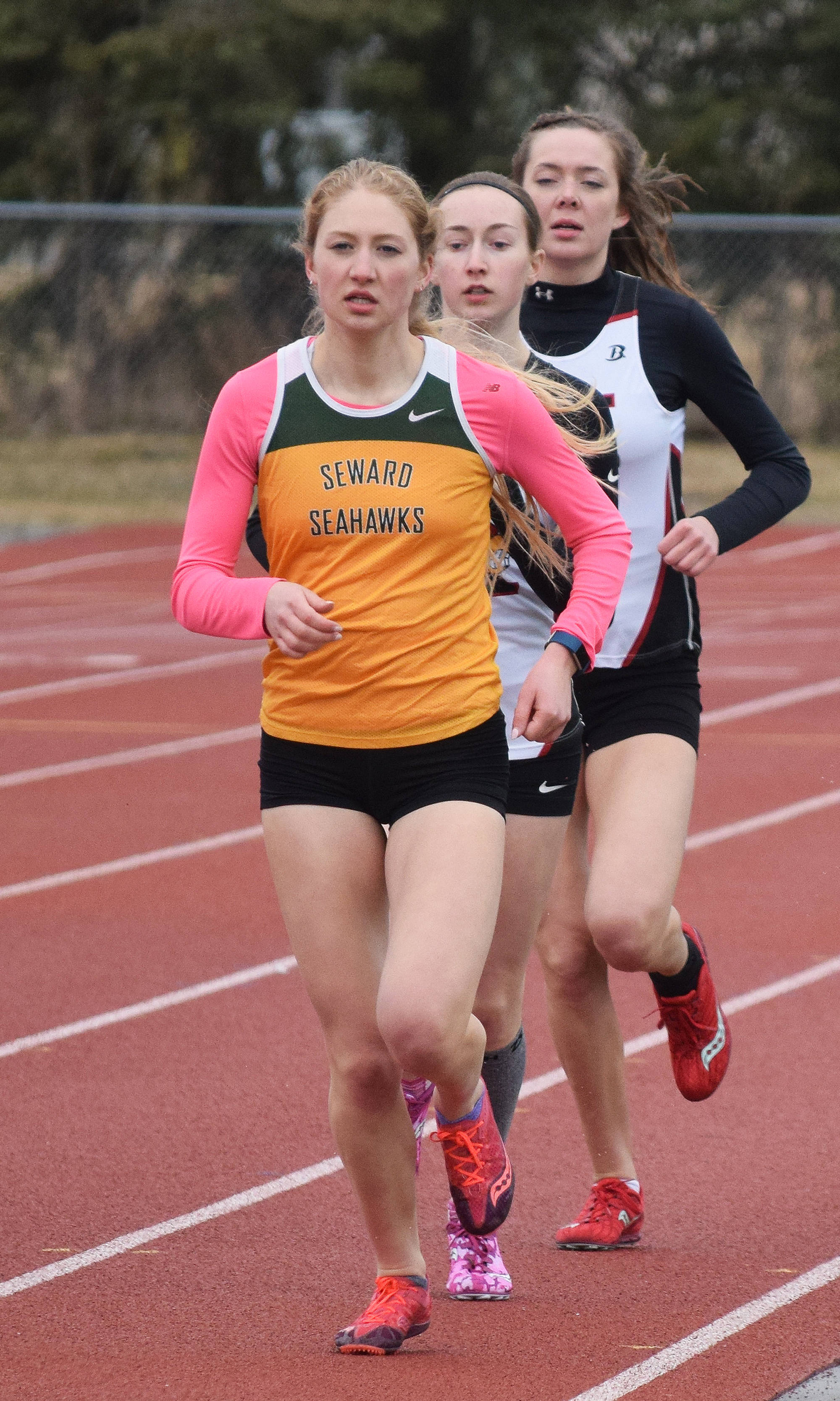 Seward senior Ruby Lindquist leads a breakaway in the girls 1,600 meters with Kenai Central juniors Jaycie Calvert and Brooke Satathite in tow Saturday at the Kenai Invitational at Ed Hollier Field. (Photo by Joey Klecka/Peninsula Clarion)