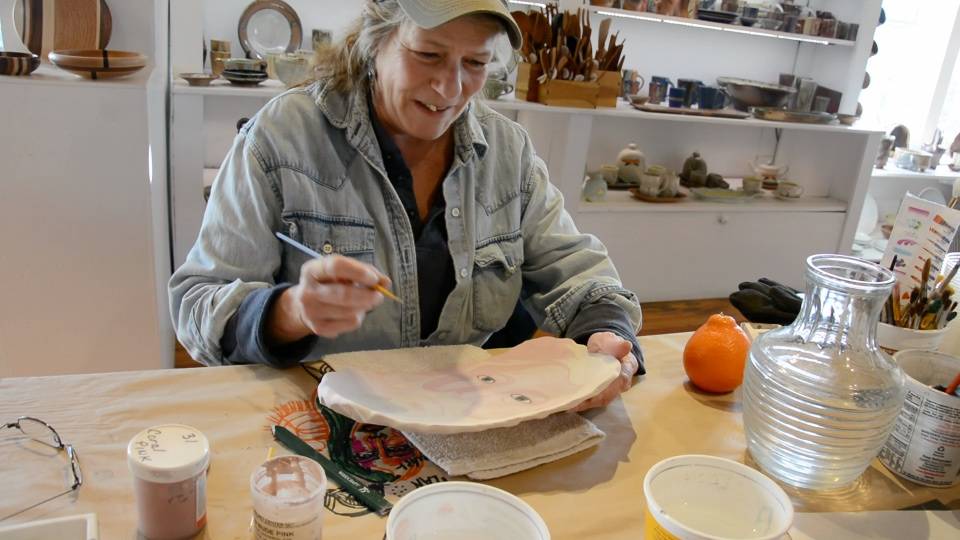 Beth McKinney paints a plate for Bunnell Street Arts Center’s annual Plate Project. (Photo provided)