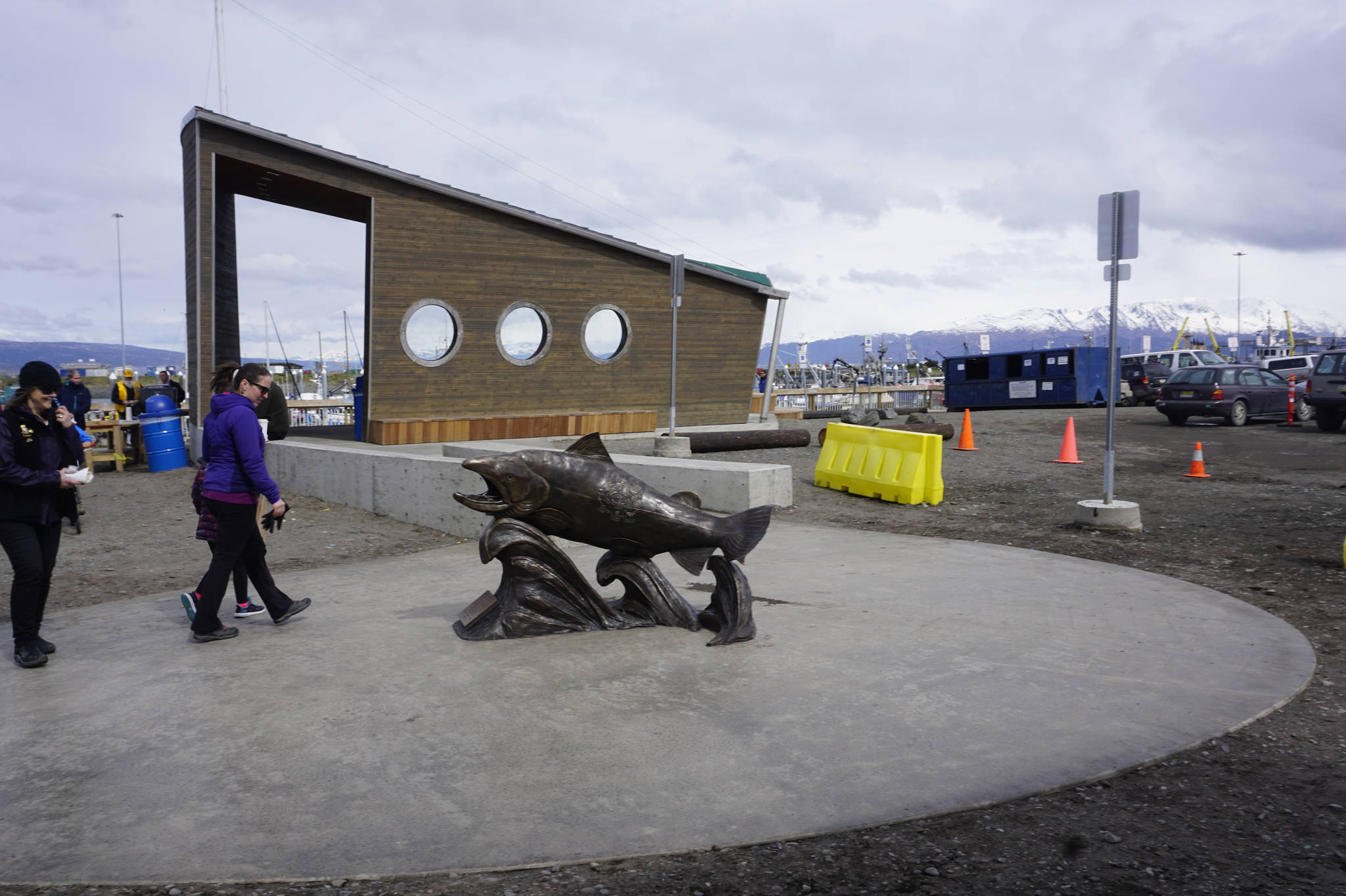 People walk by Wildheart, the Giving Salmon, sculpture Saturday, May 12, 2018 after the ribbon cutting for the Homer Boat House. (Photo by Michael Armstrong/Homer News)
