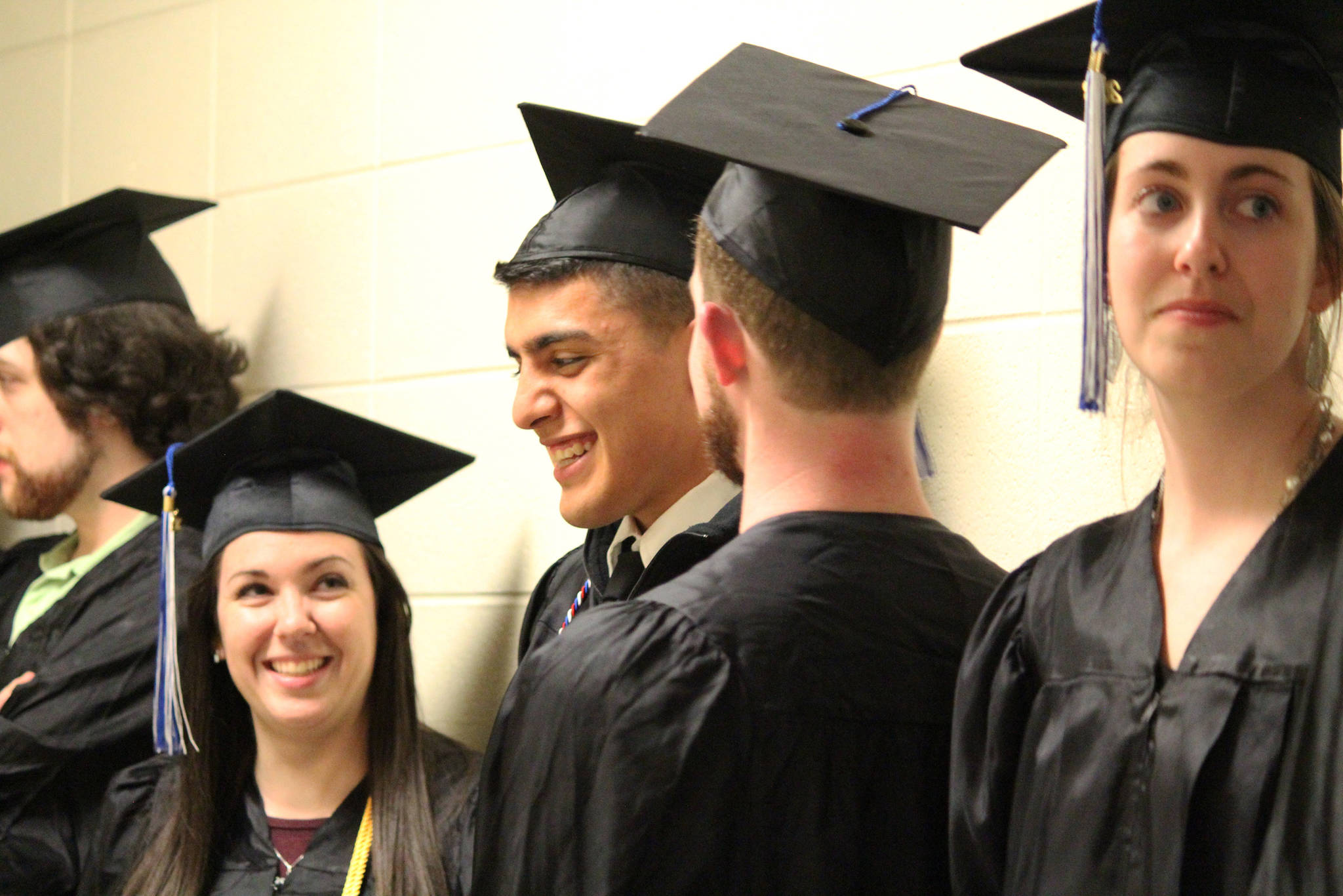 Kachemak Bay Campus graduate Pedro Ochoa Jr. (center) laughs with classmates before their commencement ceremony Wednesday, May 9, 2018 at Homer High School in Homer, Alaska. (Photo by Megan Pacer/Homer News)
