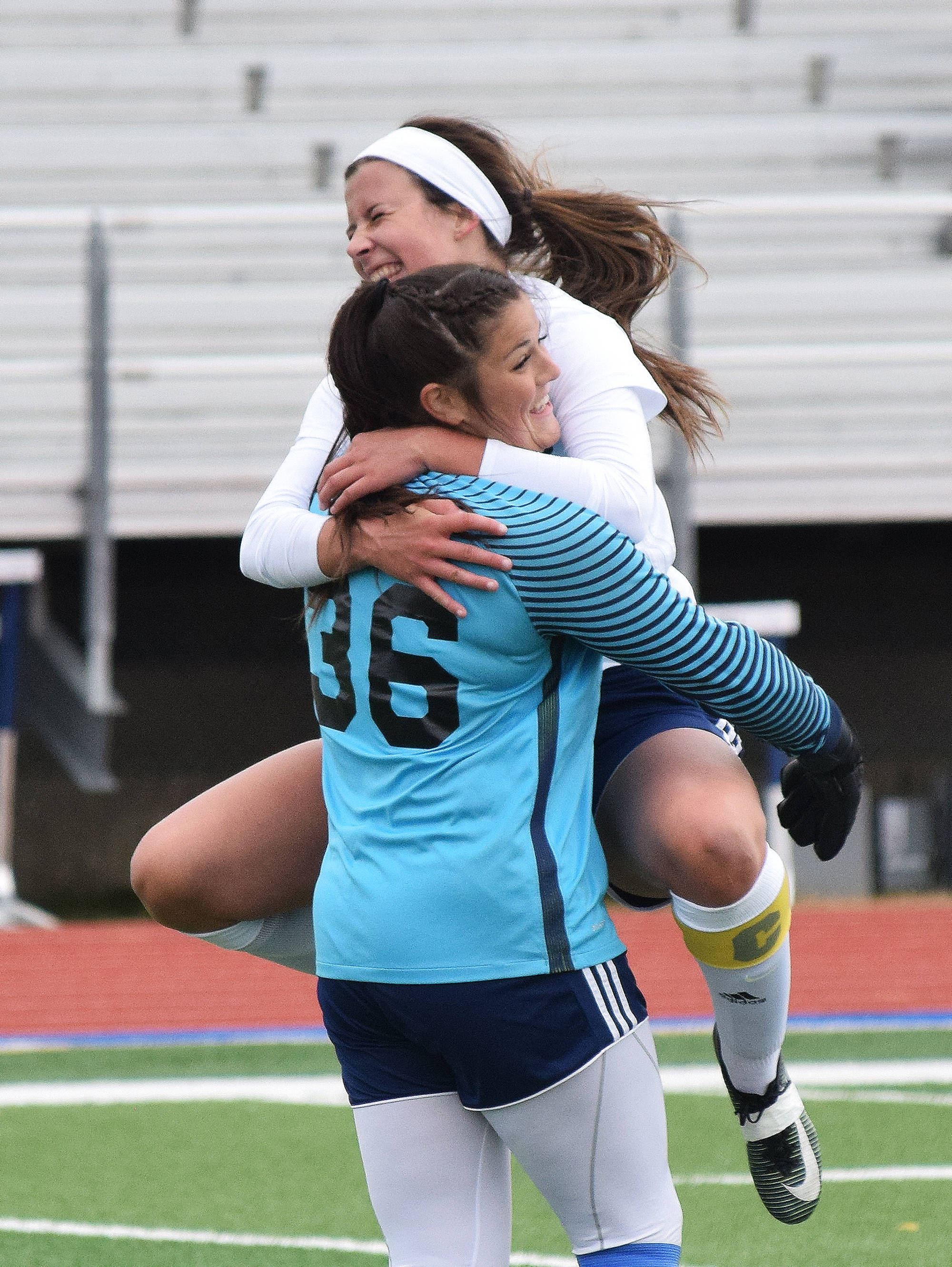 Soldotna teammates Maddie Kindred (36) and Whitney Wortham celebrate moments after winning the Peninsula Conference girls soccer championship Saturday at Soldotna High School. (Photo by Joey Klecka/Peninsula Clarion)