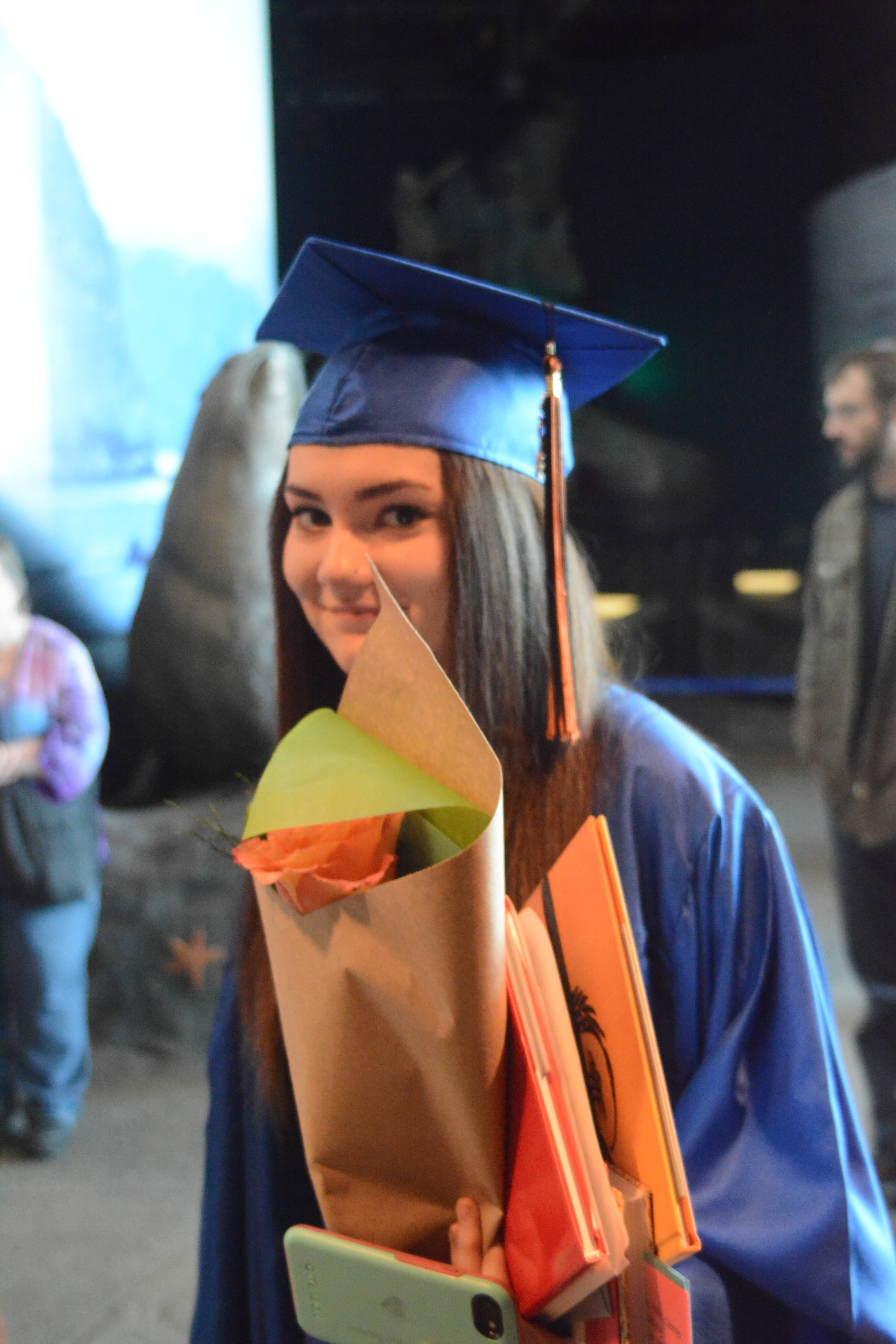 Flex High School graduate Emily Baylink holds roses and gift books after graduating. Nine students graduated from Flex on Tuesday night, May 22, 2018, at the Alaska Islands and Ocean Visitor Center auditorium, Homer, Alaska. (Photo by Michael Armstrong / Homer News)