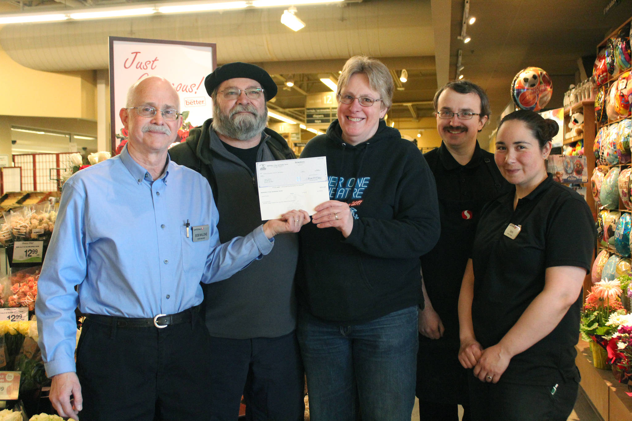 From left to right: Homer Safeway Store Manager Bob Malone, Peter Norton, Laura Norton, Chris Long and Tasha Taylor pose with a check being presented to Laura Norton on Tuesday, May 22, 2018 at the grocery store in Homer, Alaska. Norton won $20,000 through the Safeway Monopoly Game. (Photo by Megan Pacer/Homer News)