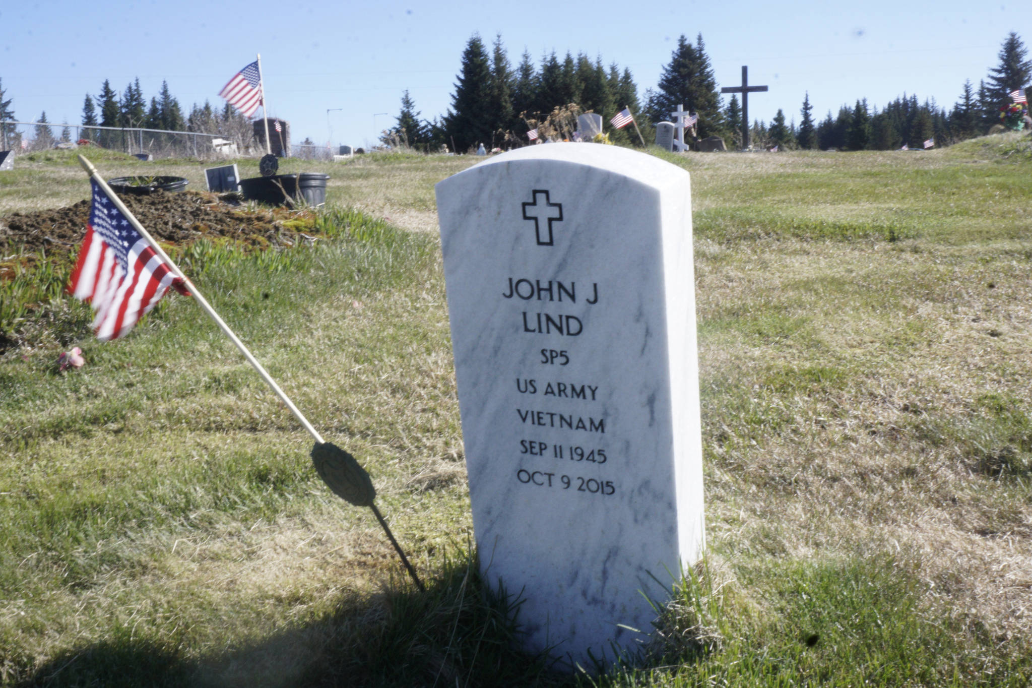 The grave of Vietnam War veteran John J. Lind is one of dozens of graves for veterans decorated by American flags on Memorial Day, May 28, 2018, at Hickerson Memorial Cemetery, Homer. Veterans buried there have served in World War I, World War II, the Korean War and the Vietnam War. (Photo by Michael Armstrong / Homer News)
