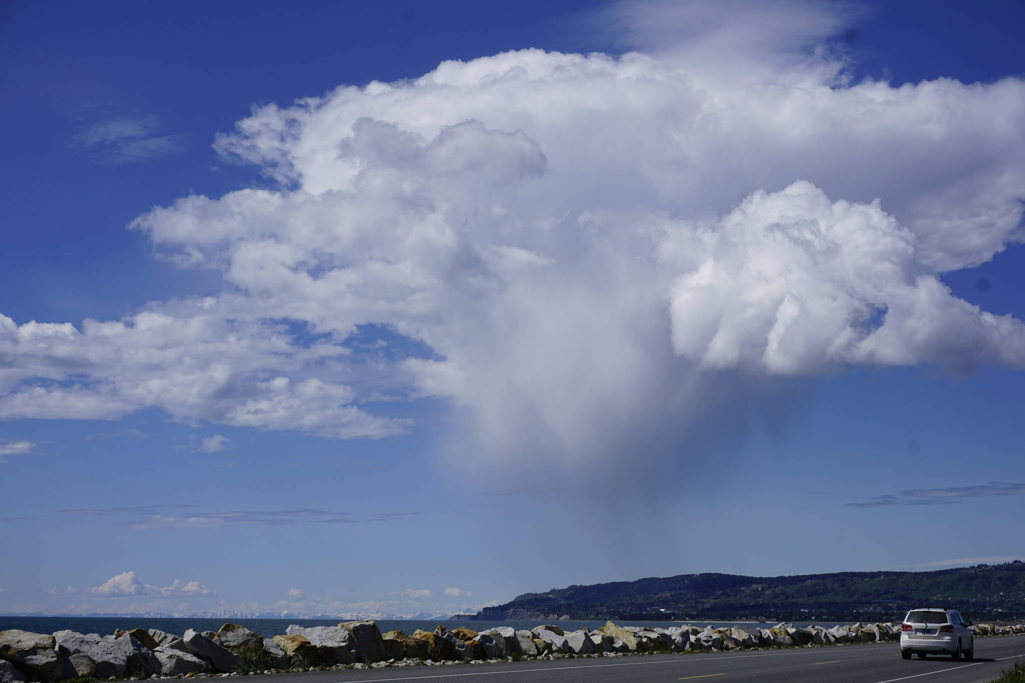 A rain cloud hangs over the hills above Homer on Friday, June 1, as seen from the Homer Spit Road. (Photo by Michael Armstrong/Homer News)