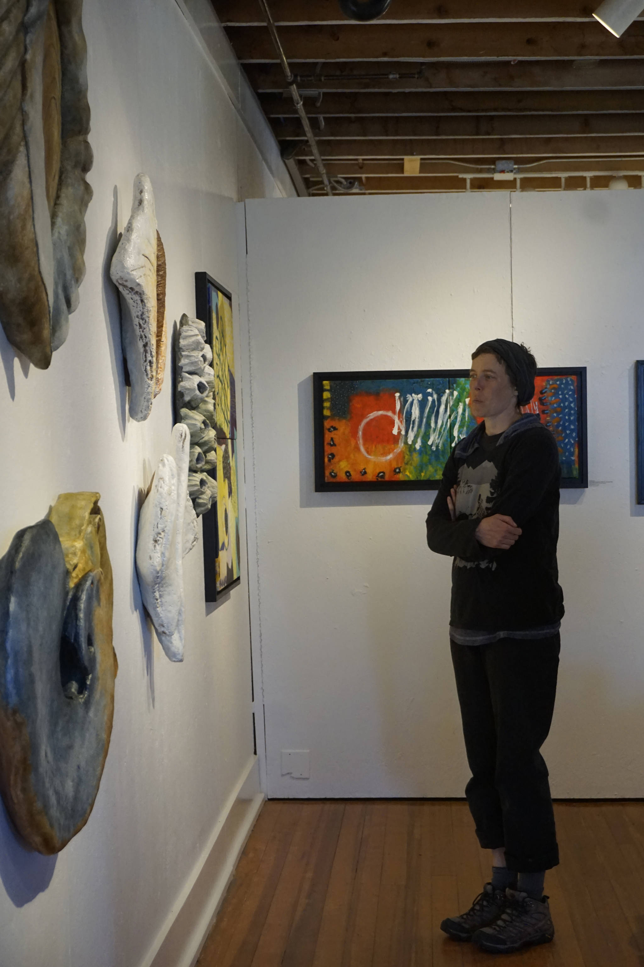 Kim McNett looks at some of Melisse Reichman’s sculptures depicting Kachemak Bay marine life examined at a large scale. Reichman’s show is on display with paintings by Graham Dane at Bunnell Street Arts Center through June. (Photo by Michael Armstrong/Homer News)