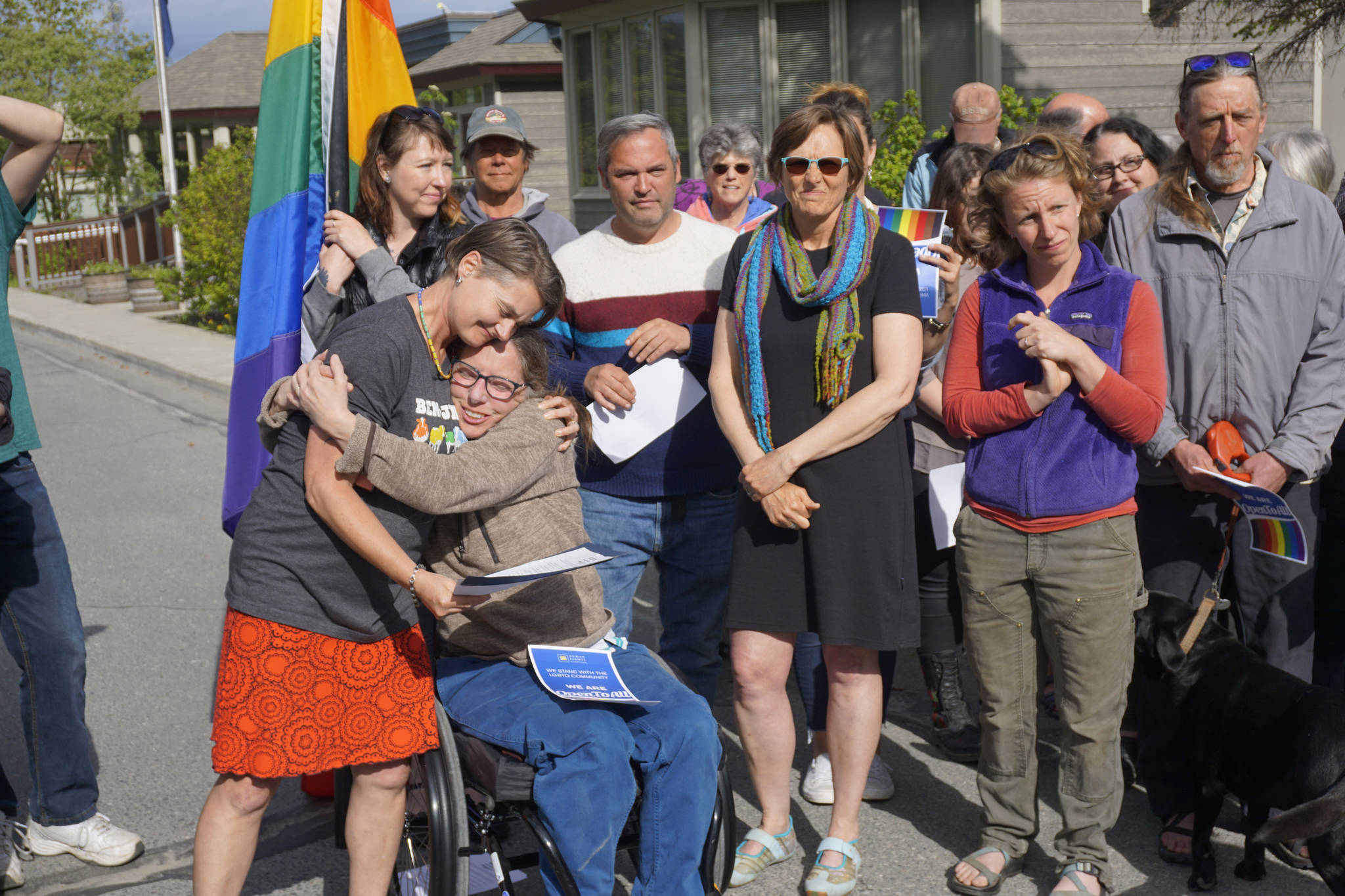 Catriona Reynolds, left, hugs Tess Dally, right, after Homer Mayor Bryan Zak read a Mayoral Recognition recognizing June as Homer Pride Month at about 6 p.m. Monday, June 11, 2018 outside Homer City Hall in Homer, Alaska. A crowd of about 75 people attended in support of Pride Month. Council members Shelly Erickson, Heath Smith and Thomas Stroozas notified the city clerk that they would not attend the June 11 meeting, forcing its cancellation because of lack of a quorum. Listening are council members Donna Aderhold, third from right, and Rachel Lord, second from right. (Photo by Michael Armstrong/Homer News)