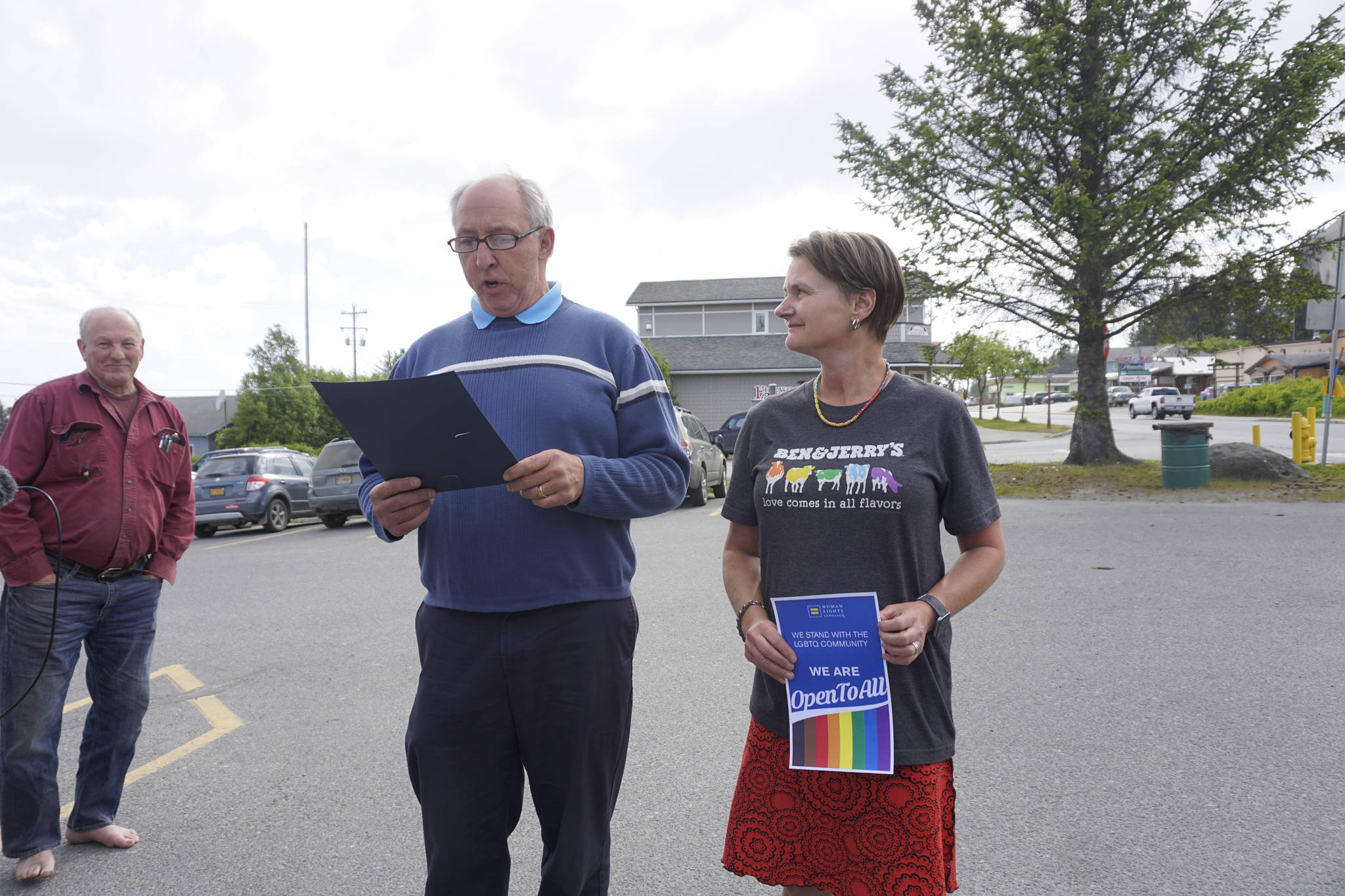 Homer Mayor Bryan Zak reads a Mayoral Recognition recognizing June as Homer Pride Month at about 6 p.m. Monday, June 11, 2018 outside Homer City Hall in Homer, Alaska. A crowd of about 75 people attended in support of Pride Month. Council members Shelly Erickson, Heath Smith and Thomas Stroozas notified the city clerk that they would not attend the June 11 meeting, forcing its cancellation because of lack of a quorum. Catriona Reynolds, right, listens to Zak. She asked the mayor for the recognition. (Photo by Michael Armstrong/Homer News)
