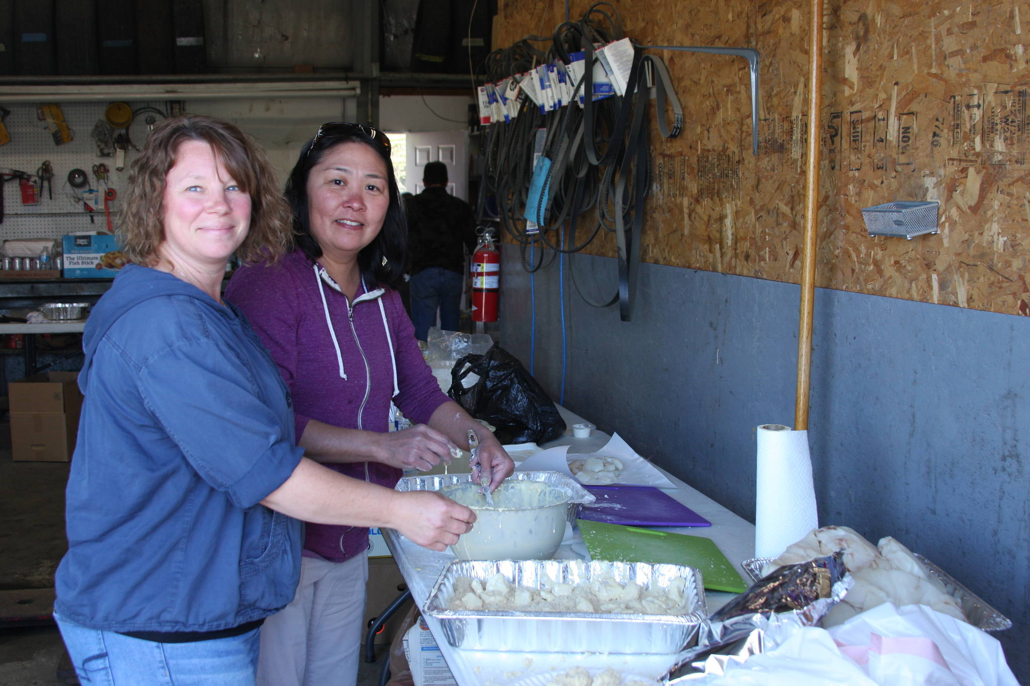(From left to right) Brandi Blauvelt, daughter of owners Elaine and Dale Griner, and Thurmond’s employee Janet George prepare fresh deep-fried halibut for those attending the fourth annual Thurmond’s Far West Auto Customer Appreciation Day on Saturday, June 9 in Anchor Point, Alaska. (Photo by Delcenia Cosman)