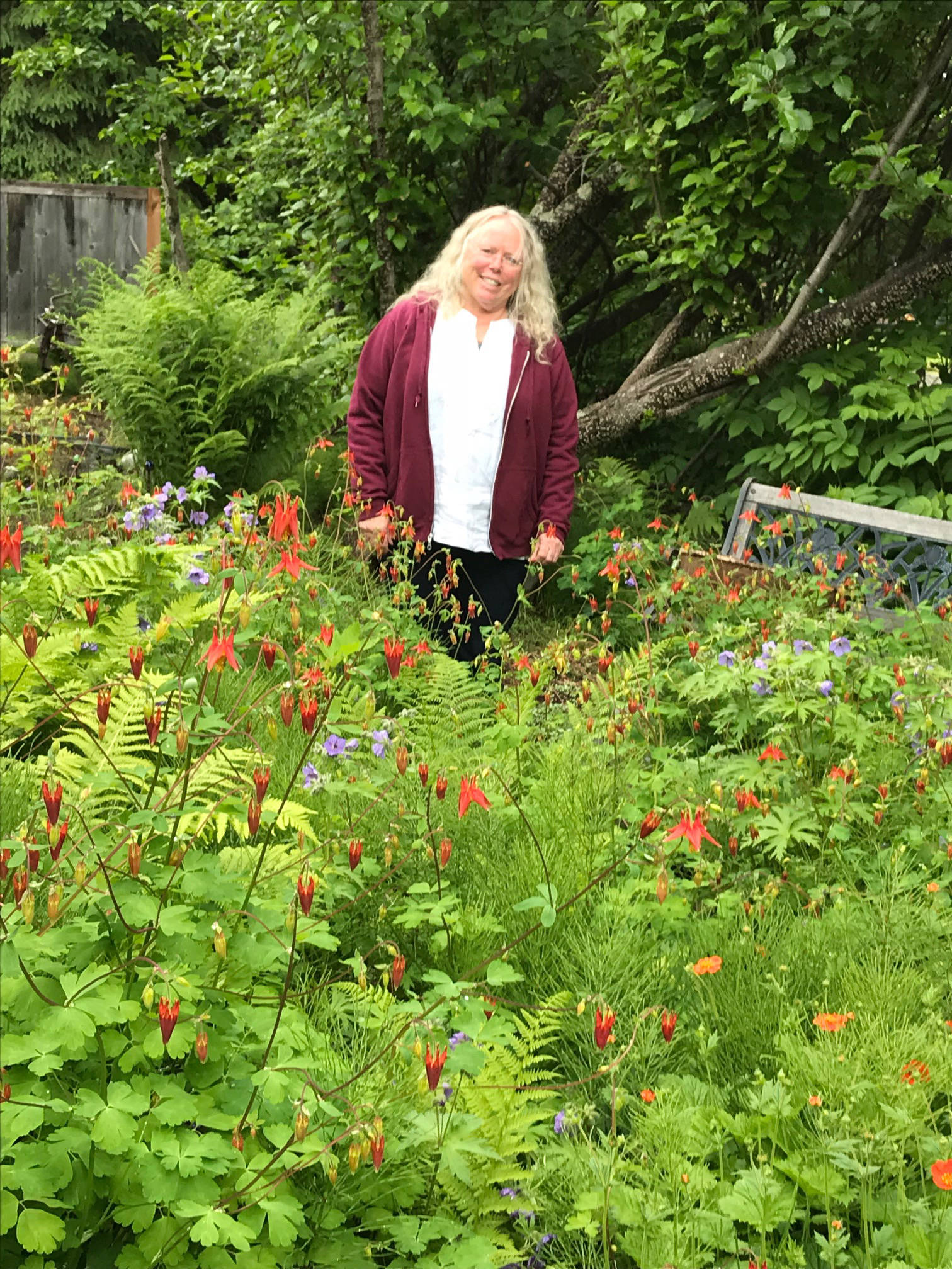 Judy Flora stands among columbine in Homer, Alaska, on June 29, 2018, her penchant for the flowers realized. (Photo by Rosemary Fitzpatrick)