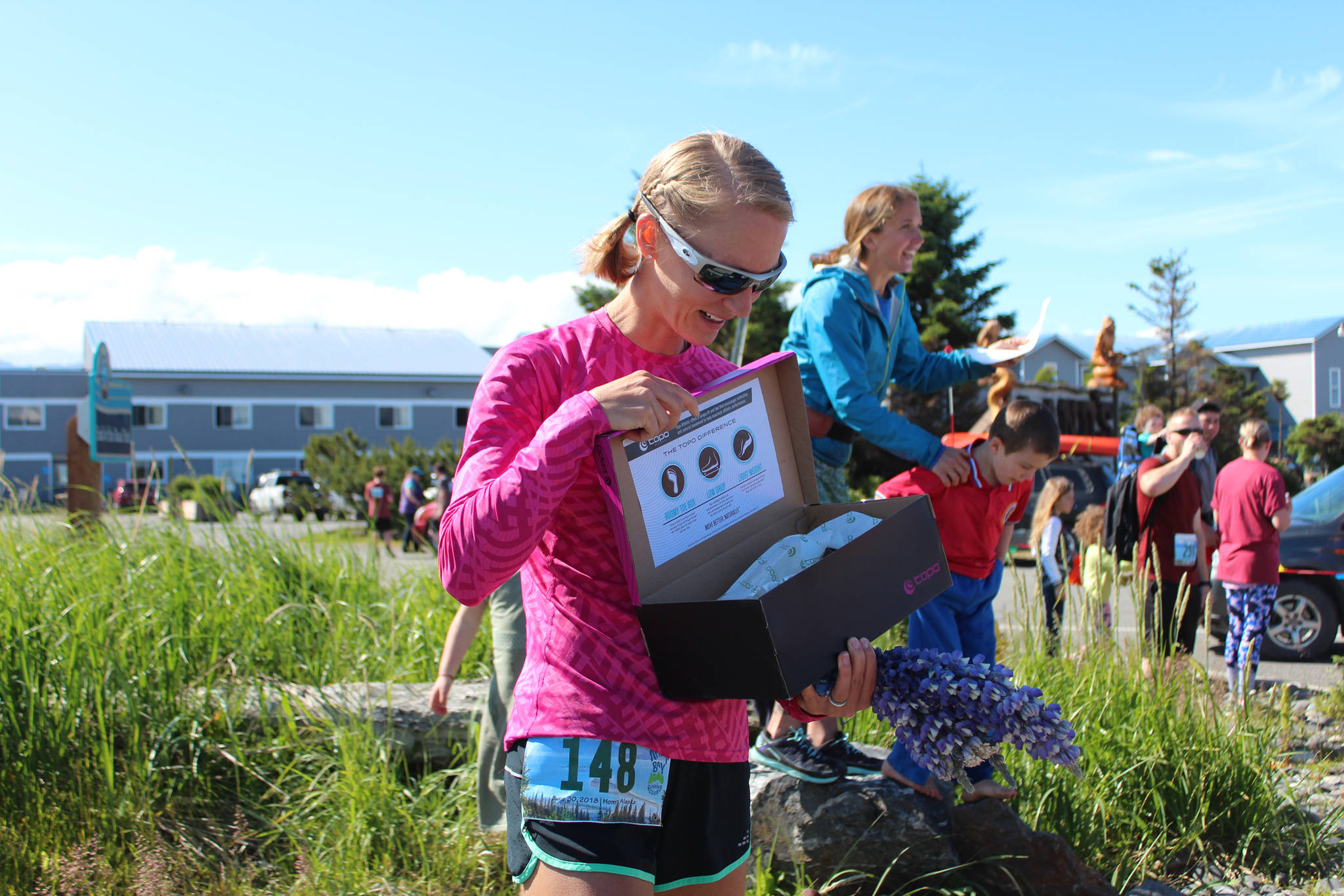 <span class="neFMT neFMT_PhotoCredit">Photo by Megan Pacer/Homer News</span>                                Heidi Bock, of Texas, looks inside a shoebox at her prize for taking first place in the Cosmic Hamlet Half Marathon for the women Saturday, June 30 during the Homer Spit Run at Land’s End Resort in Homer. Winners were appropriately gifted a pair of running shoes.