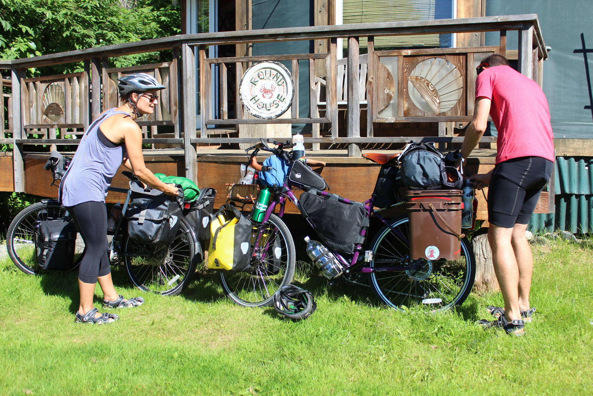 Sophie George and Chris Haag put the finishing touches on their bikes before setting off on a two-year trek from Alaska to Argentina on Monday, July 2, 2018 on Hidden Way in Homer, Alaska. The husband and wife packed up their life in Utah prior to the adventure. (Photo by Megan Pacer/Homer News)