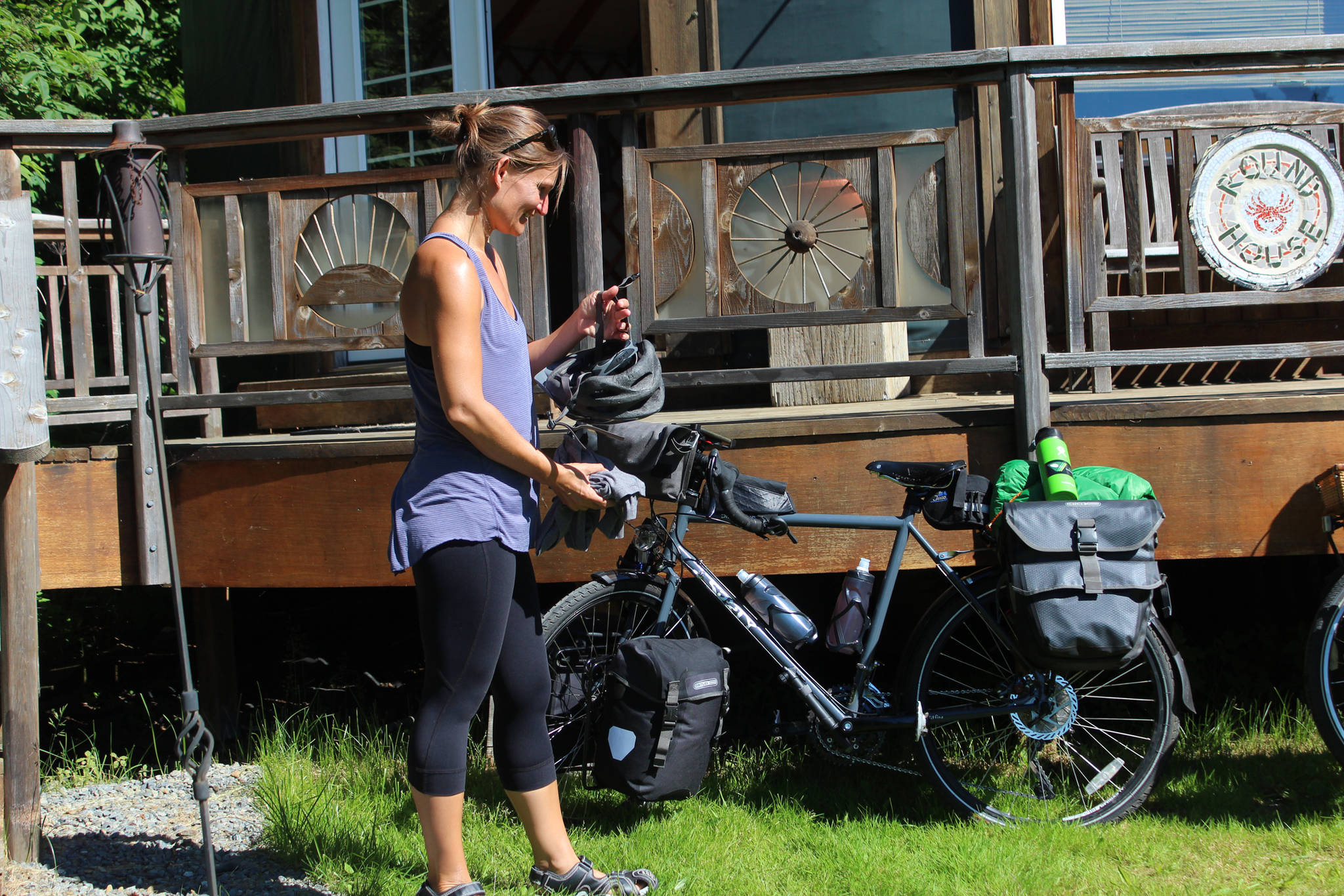 Sophie George prepares to mount her bicycle for a trip from Alaska to Argentina with her husband, Chris Haag, on Monday, July 2, 2018 in Homer, Alaska. The pair set off from a yurt they rented on Hidden Way. (Photo by Megan Pacer/Homer News)