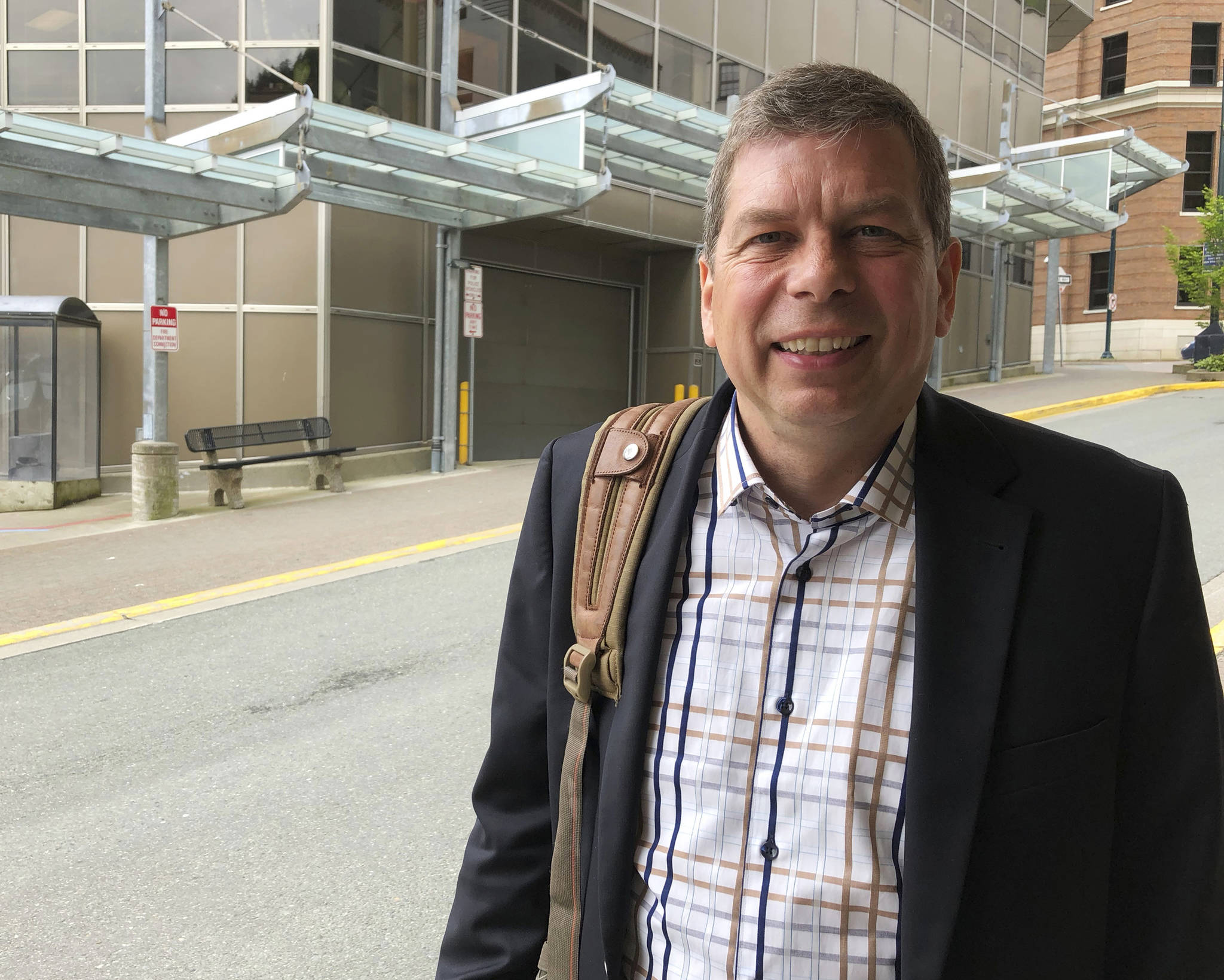 In this June 28, 2018, photo, Democrat Mark Begich, a candidate for governor in Alaska and a former U.S. senator, poses outside a downtown office building in Juneau, Alaska. Begich is seeking to ease concerns some have about his entry into the race, saying he would not be running if he did not think he could win. The race is shaping up to be a three-way, general election contest between Begich, independent Gov. Bill Walker and the eventual Republican nominee. (AP Photo/Becky Bohrer)
