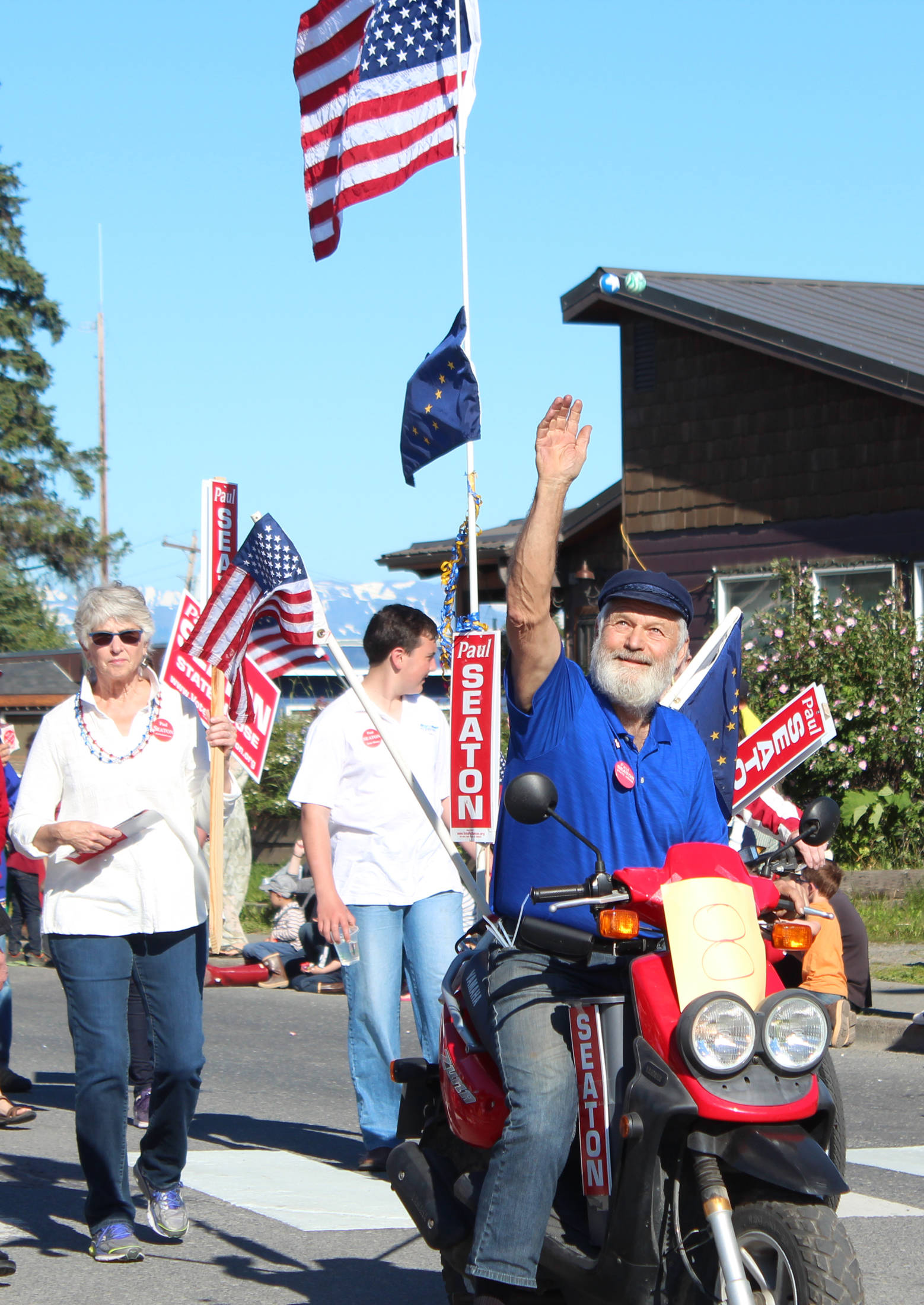 Rep. Paul Seaton (R-Homer) tosses bouncy balls into the air for children to run after from his position in this year’s Independence Day parade Wednesday, July 4, 2018 on Pioneer Avenue in Homer, Alaska. (Photo by Megan Pacer/Homer News)