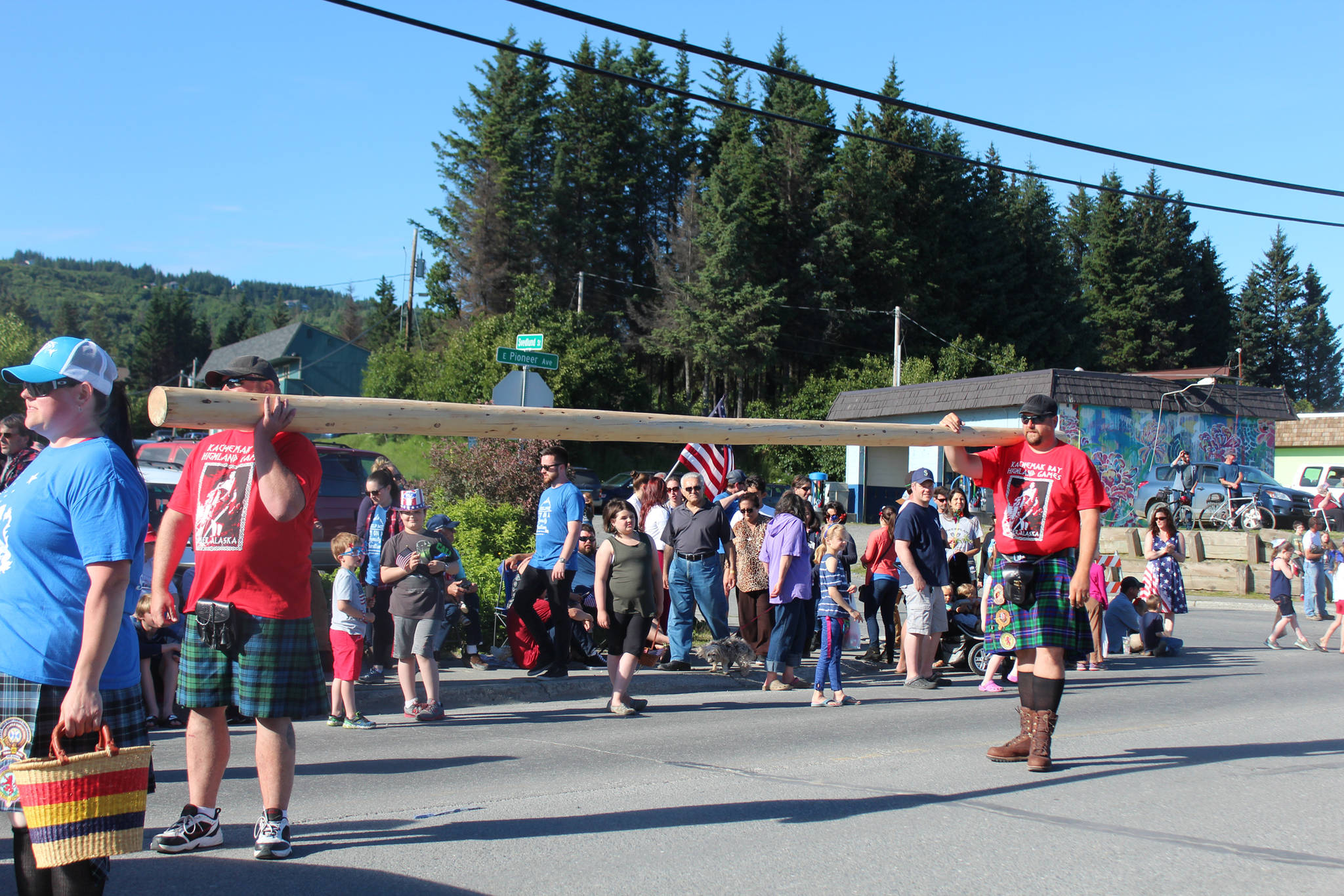 Two men carry a caber — a type of log thrown during Scottish highland games — during the annual Independence Day parade Wednesday, July 4, 2018 on Pioneer Avenue in Homer, Alaska. (Photo by Megan Pacer/Homer News)