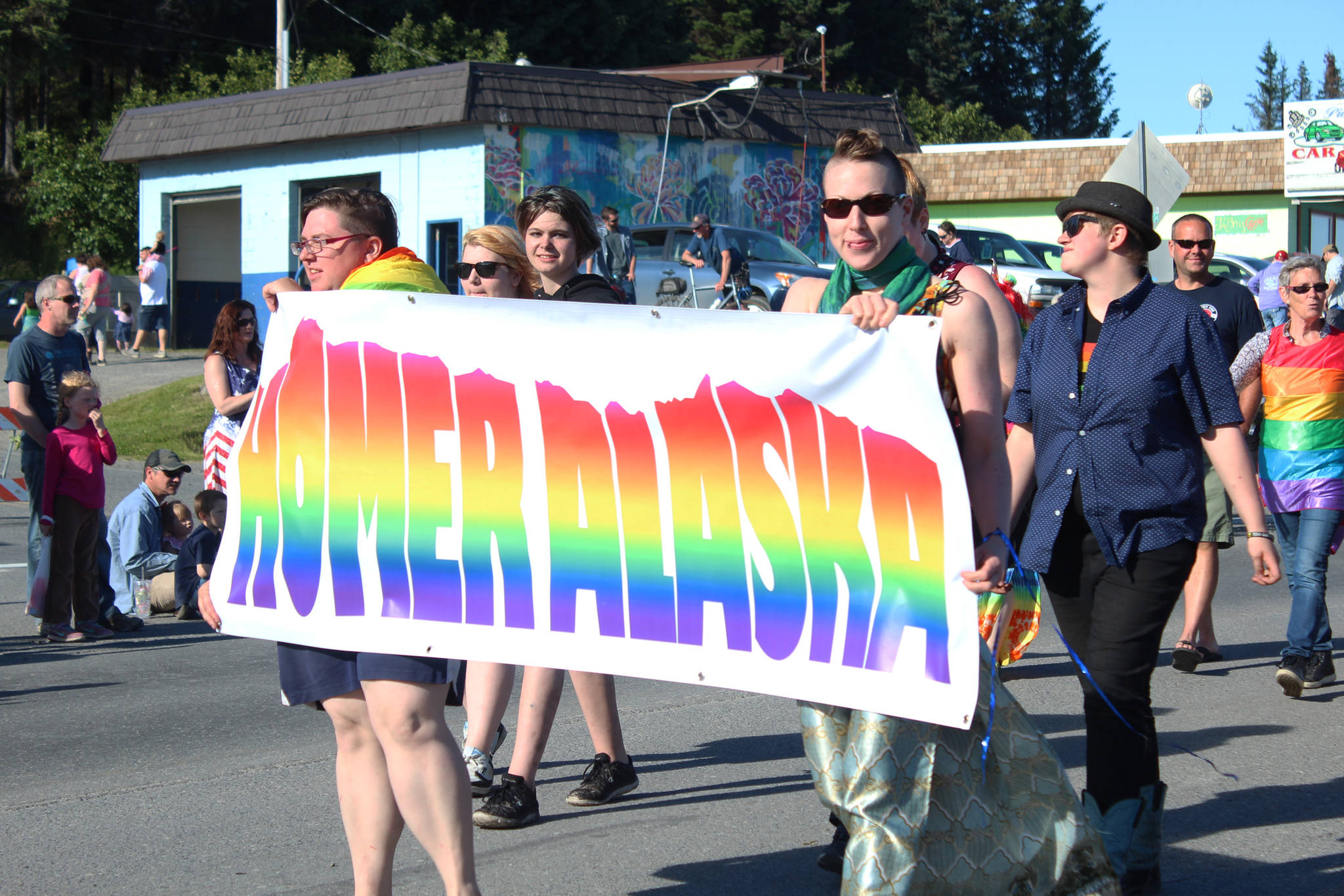 A small crowd of people march in the LGBTQ Pride section of the annual Independence Day parade Wednesday, July 4, 2018 along Pioneer Avenue in Homer, Alaska. (Photo by Megan Pacer/Homer News)