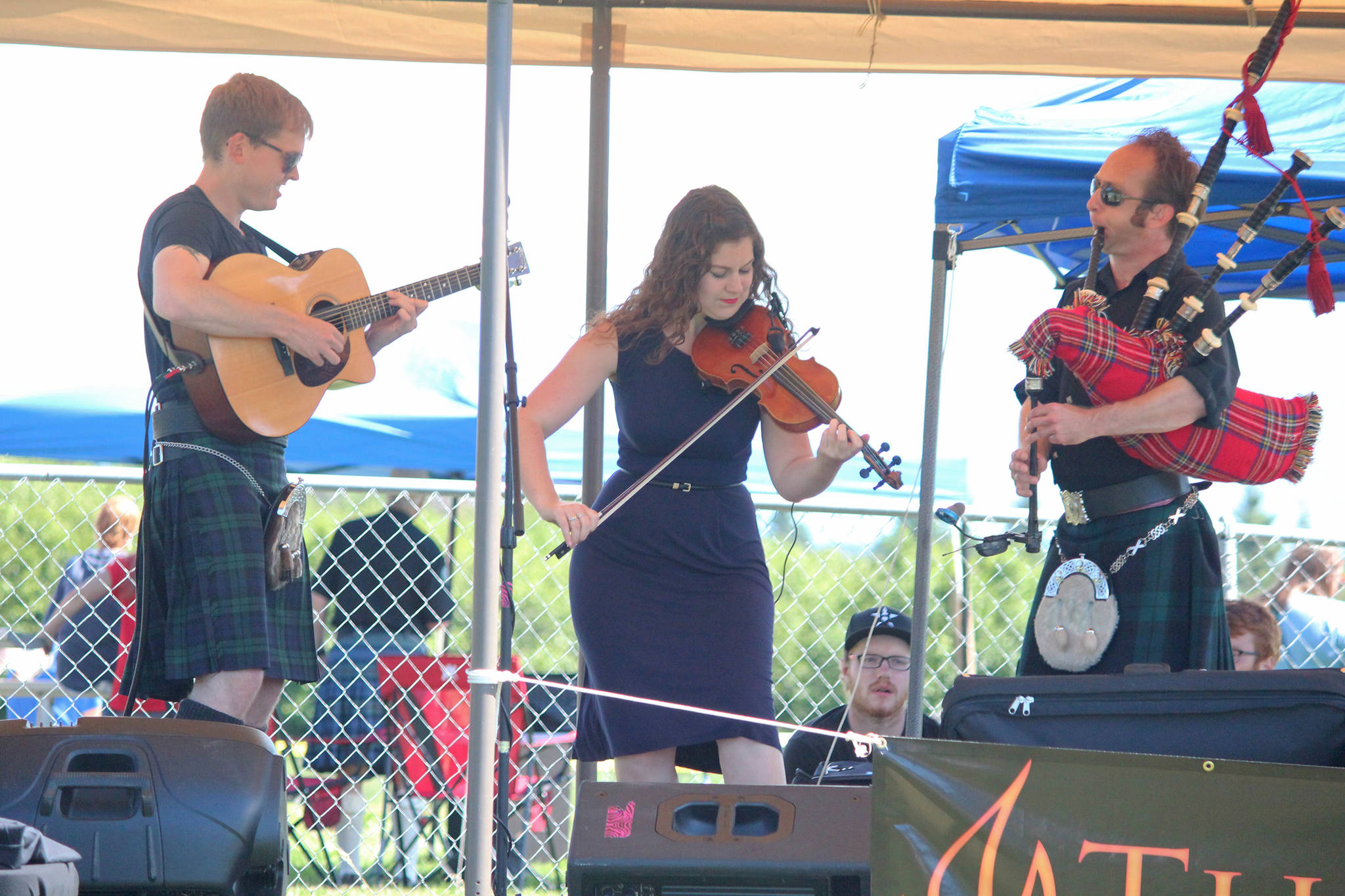 Members of the Scottish band The Fire perform on a small stage at the Kachemak Bay Scottish Highland Games on Saturday, July 7, 2018 at Karen Hornaday Park in Homer, Alaska. The trio also performed at an after party at the Kannery Grill later that evening. (Photo by Megan Pacer/Homer News)