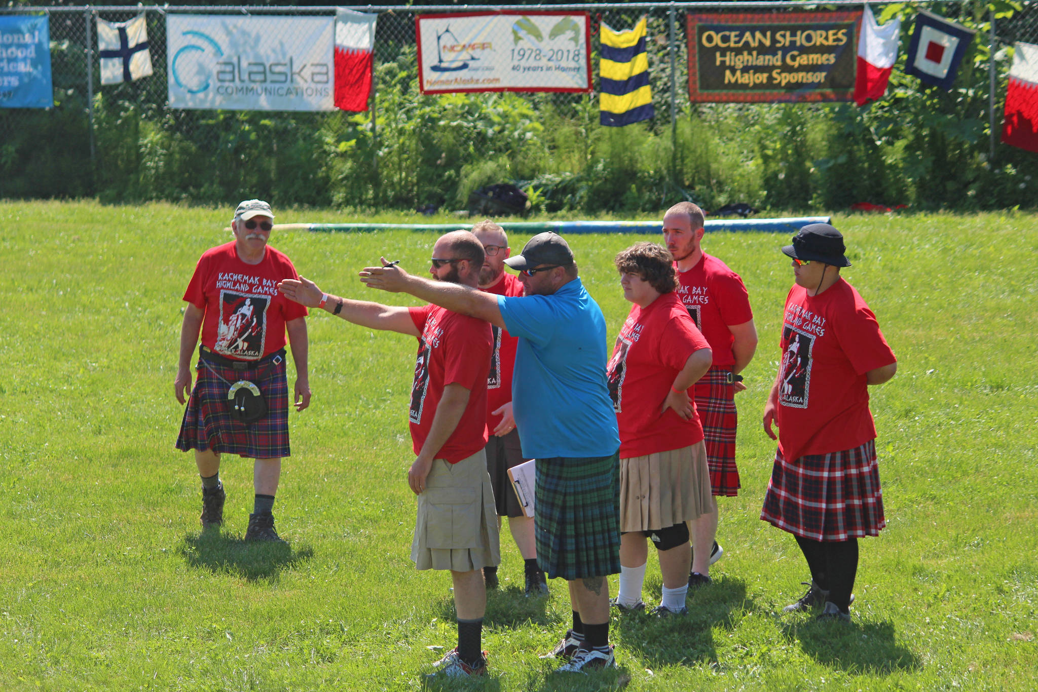 A coach gives novice competitors advice on how to throw a caber on Saturday, July 7, 2018 during the Kachemak Bay Scottish Highland Games at Karen Hornaday Park in Homer, Alaska. Novices must practice before actually participating in the caber throw. (Photo by Megan Pacer/Homer News)