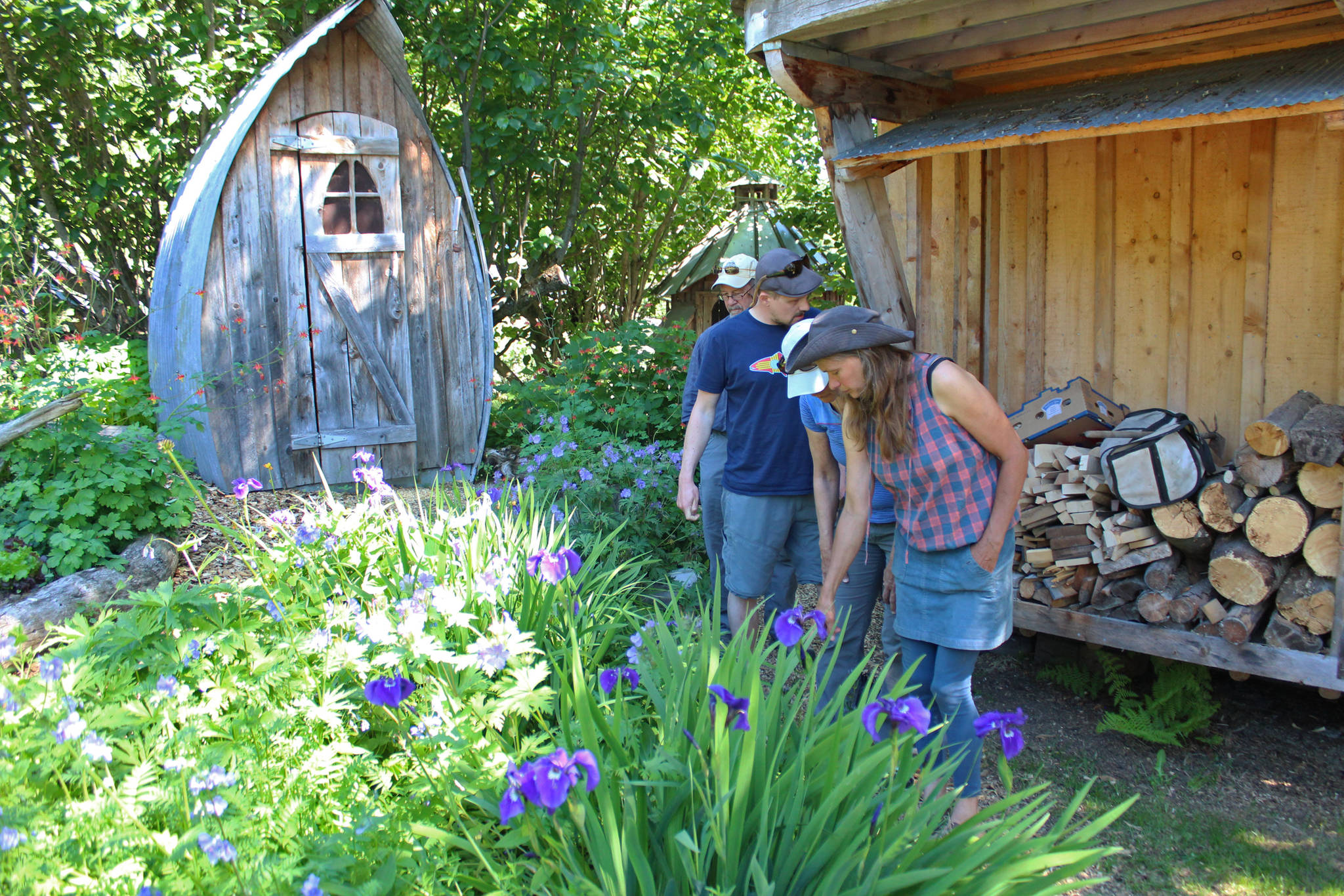 Ranja Dean leads a tour through her extensive gardens Friday, July 6, 2018 at her home off East End Road near Homer, Alaska. She and her husband host tours of their property and art studio. (Photo by Megan Pacer/Homer News)