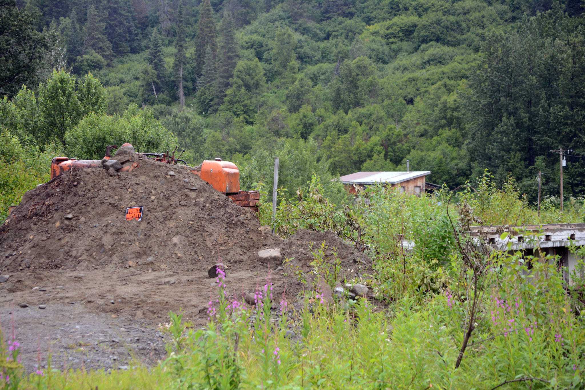 A bulldozer and a pile of gravel block the entrance to a bridge leading to the Glanville homestead on July 23, 2018, near Mile 164 Sterling Highway. Dwight and Diana Glanville filed eviction proceedings against Keith Evans, and in a hearing on July 23, Evans agreed to pack up his possessions no later than Aug. 6, at which time the Glanvilles will open the road so he can leave. (Photo by Michael Armstrong/Homer News)