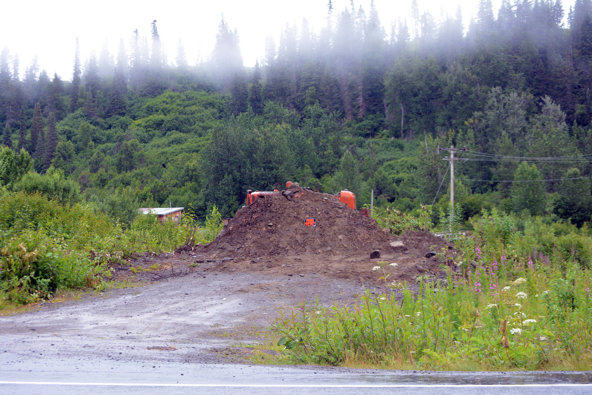A bulldozer and a pile of gravel block the entrance to a bridge leading to the Glanville homestead on July 23, 2018, near Mile 164 Sterling Highway. Dwight and Diana Glanville filed eviction proceedings against Keith Evans, and in a hearing on July 23, Evans agreed to pack up his possessions no later than Aug. 6, at which time the Glanvilles will open the road so he can leave. (Photo by Michael Armstrong/Homer News)