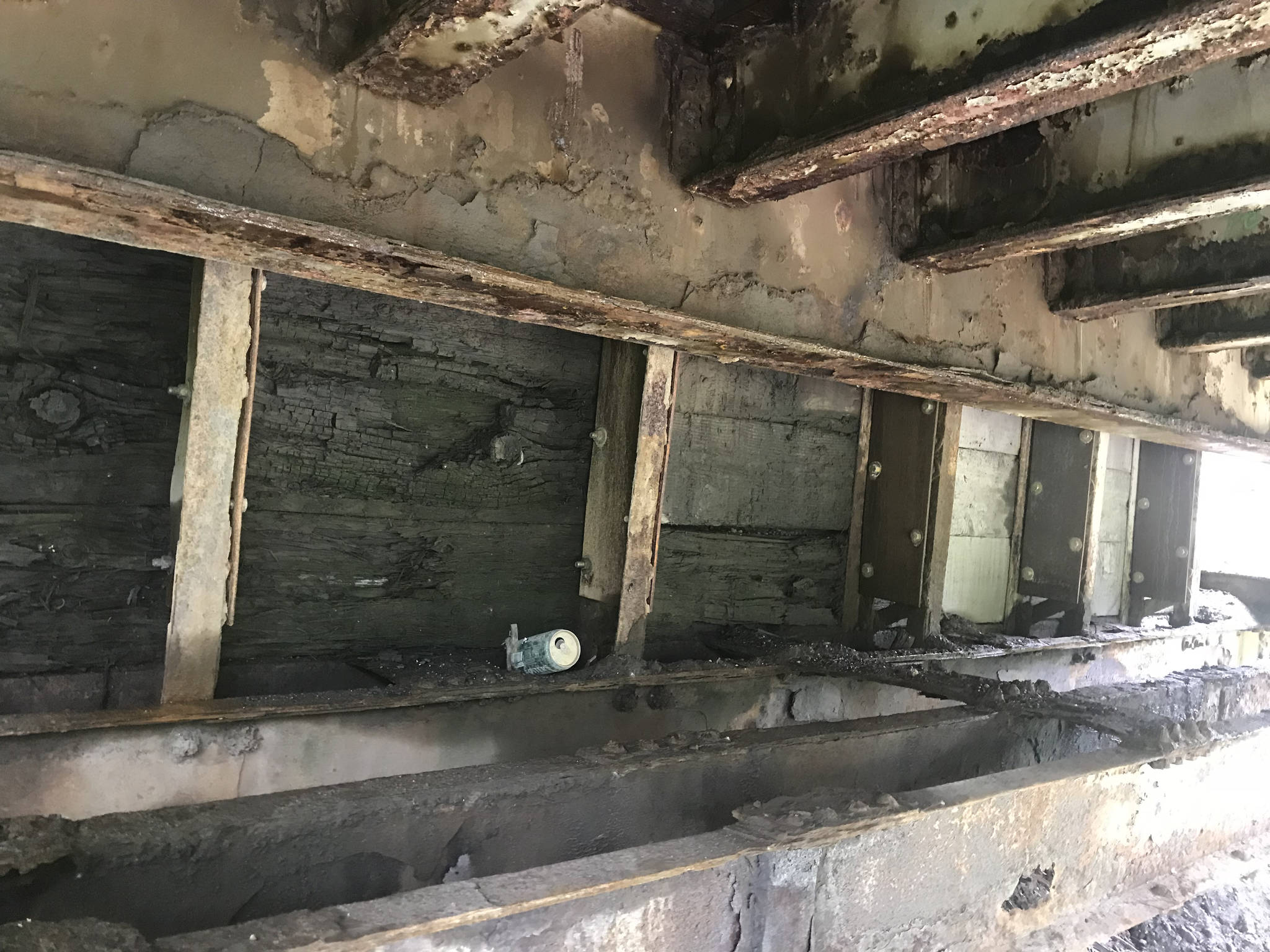 This photo taken on July 26, 2018, from underneath the Anchor River bridge abutment shows where wooden timbers have rotted on the bridge near Anchor Point, Alaska. (Photo by Paul Seaton)