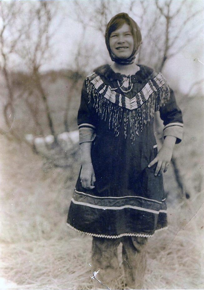 Rose Kinney Hedlund (1917–2004) in the 1930s wears the k’anyagi dress that is featured in the Dena’inaq Huch’ulyeshi exhibition. The dress is made from wool, beads, dentalium shells, caribou hide and fur. -Photo courtesy Emma Hill