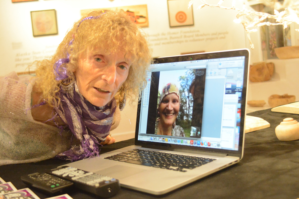 Artist and poet Jo Going, left, visits with Homer poet Eva Saulitis through a Skype connection at the opening of Going’s show, “Still and Again,” last Friday at Bunnell Street Arts Center. Saulitis is in Hawaii, and Michael Walsh of Bunnell Street Arts Center set up the Skype session so Saulitis could see the show and hear Going’s poetry reading.-Photo by Michael Armstrong, Homer News