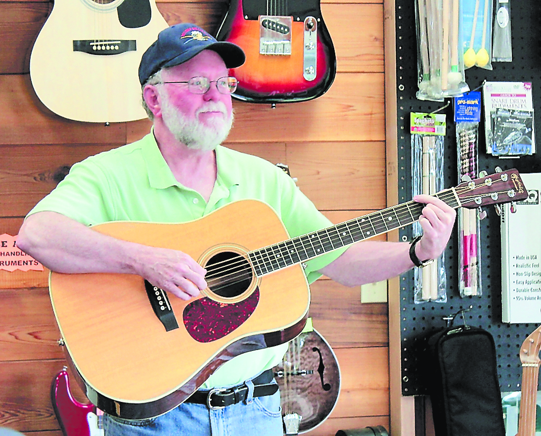 Steve Cornish plays music in his new shop, in the same building as the Art Shop Gallery.