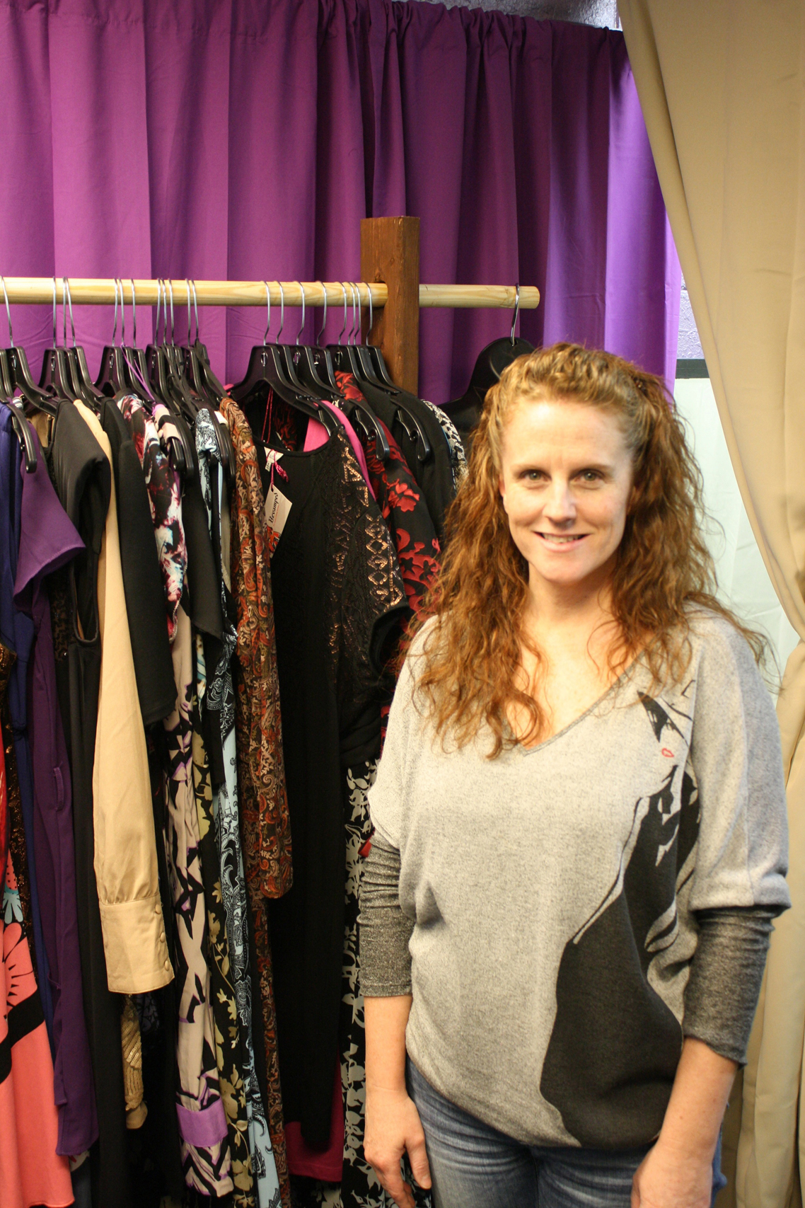 Revamped’s owner Michelle Jones pauses for a picture in front of a rack of clothes in her store at 126 W. Pioneer Ave., Suite 2.-Photo by Lindsay Olsen