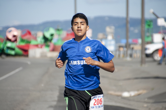 Pedro Ochoa is the first one to cross the finish line of the 2014 10K Run to the Bay Spit Run Saturday, with a time of 36:18.