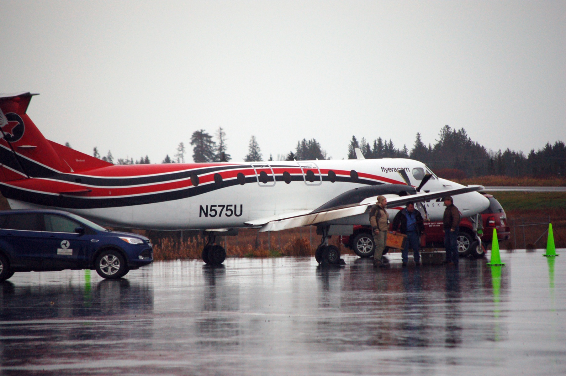 Federal Aviation Administration cars are parked at the Homer Airport next to the Era Alaska Beechwood 1900C airplane that crashed on Oct. 23, 2013. The plane has been raised on its landing gear. A carbon fiber composite propeller shows damage, as does one flap on the wing.-Photo by Michael Armstrong, Homer News