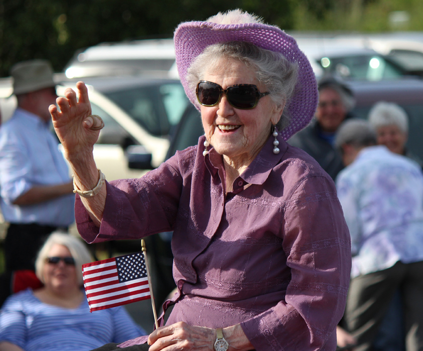 Grand Marshal Daisy Lee Bitter smiles at the crowd lining